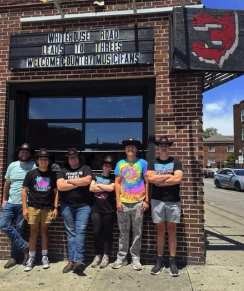 Bar staff and crew wearing matching black branded cowboy hats.