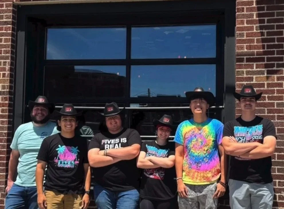 A group wearing cowboy hats outside a venue