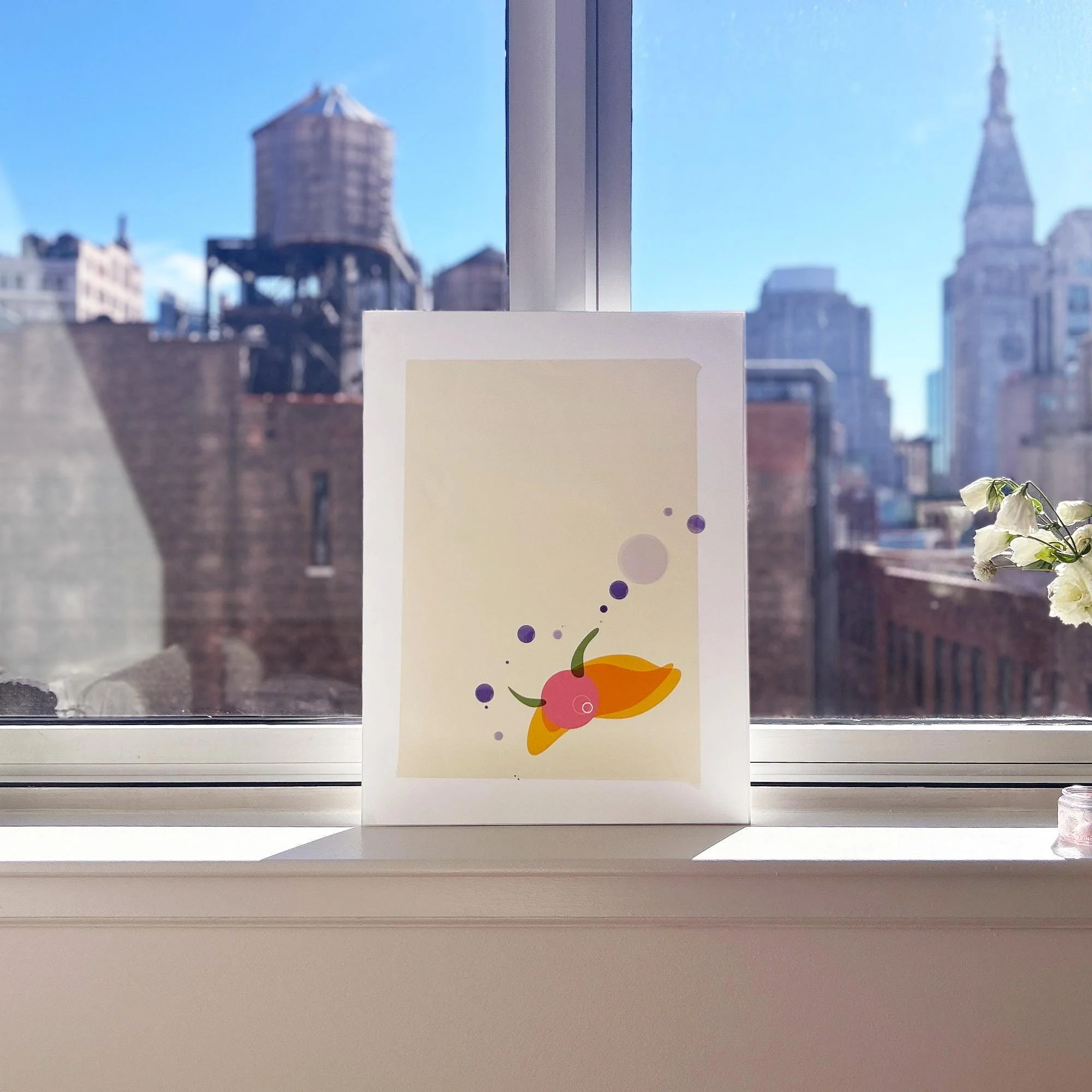 Snail Eye art print on the window sill with NYC buildingscape as backdrop, from the Wanderer collection.