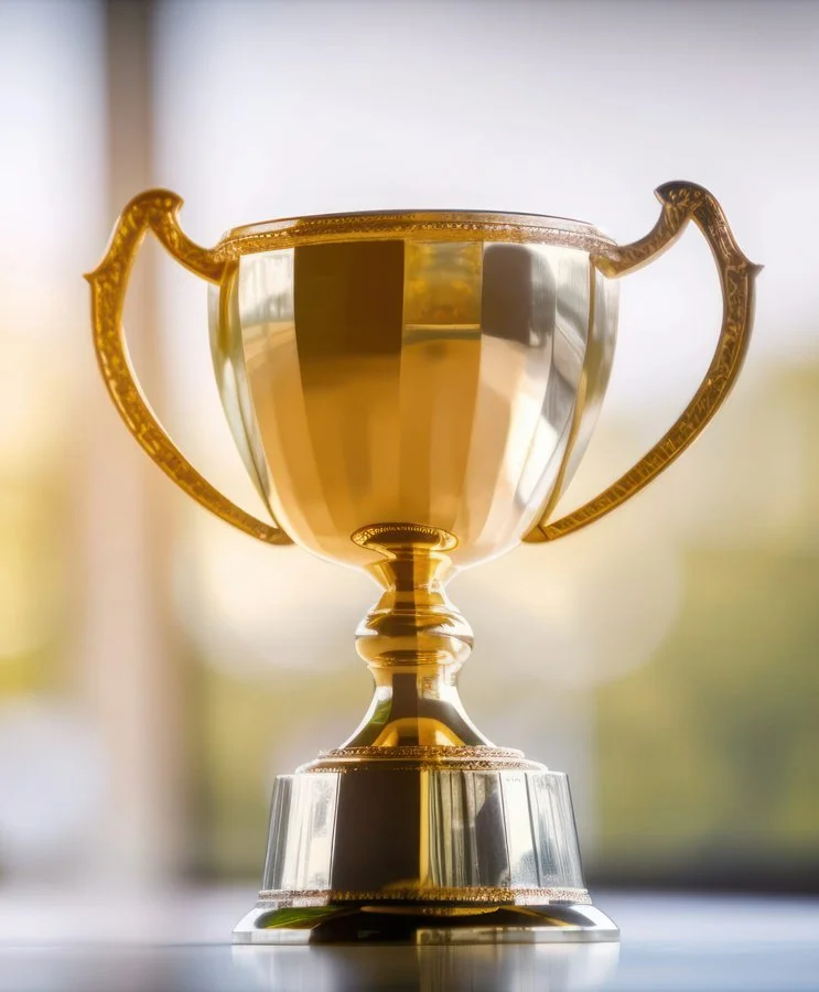 A gold trophy on a desk near a window