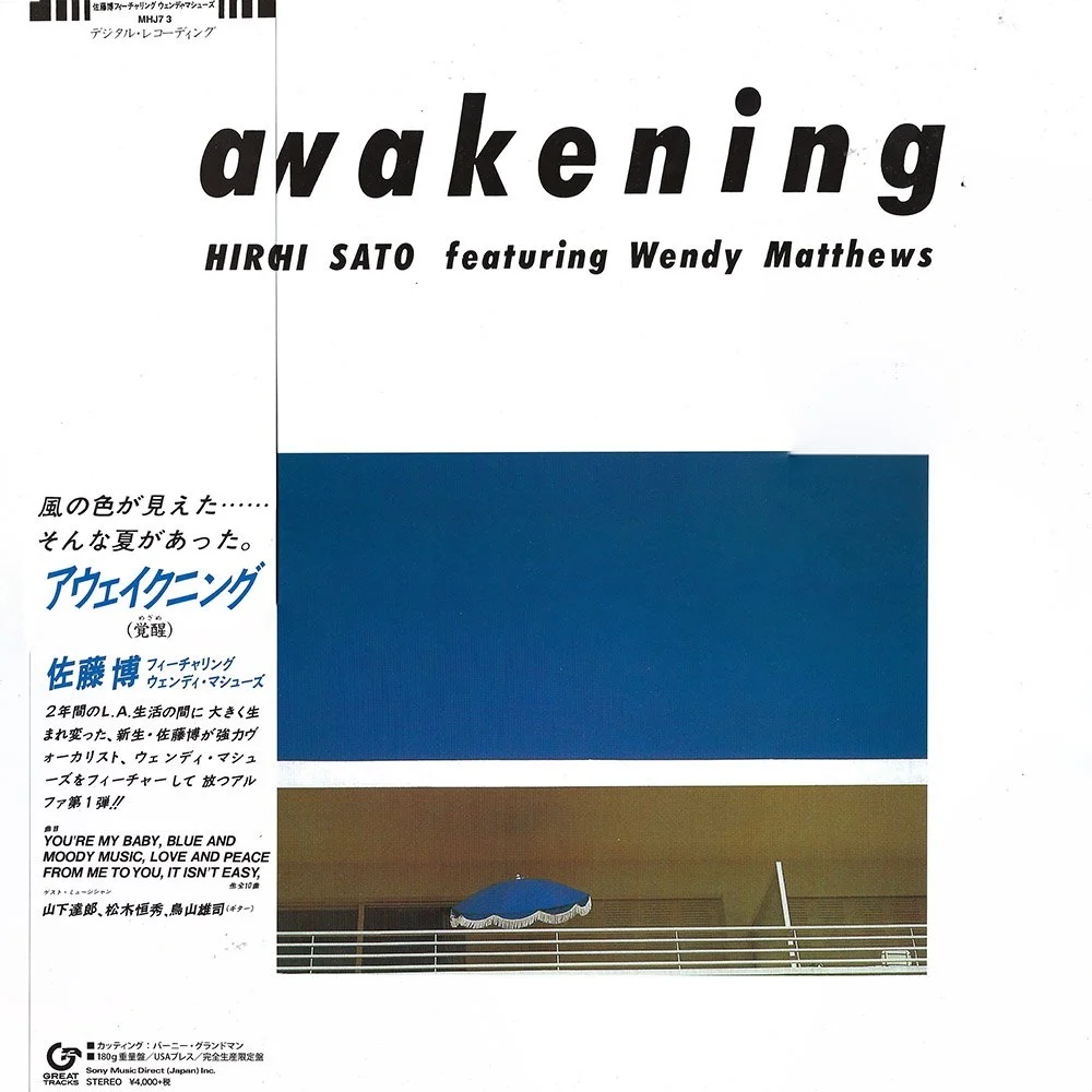 Album cover titled "Awakening" by Hiroshi Sato featuring Wendy Matthews. The cover features Japanese text, a blue rectangle above and a photo of a balcony with a blue umbrella below.