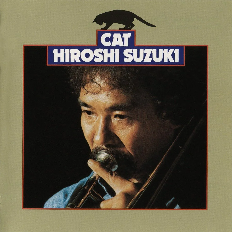 Album cover featuring a man with curly hair playing a wind instrument, with the title 'Cat' and artist name 'Hiroshi Suzuki' at the top, and a silhouette of a cat at the top center.