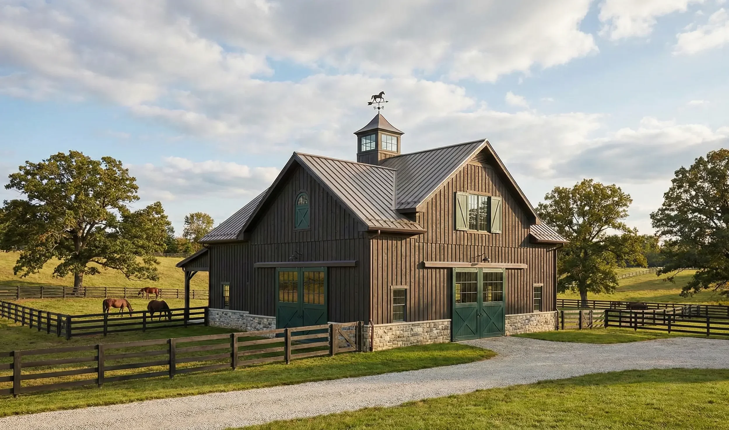 Exterior painting of a luxury equestrian barn in Wayne, IL. Features dark board-and-batten wood siding, metal roof, and green carriage doors on a large estate property.