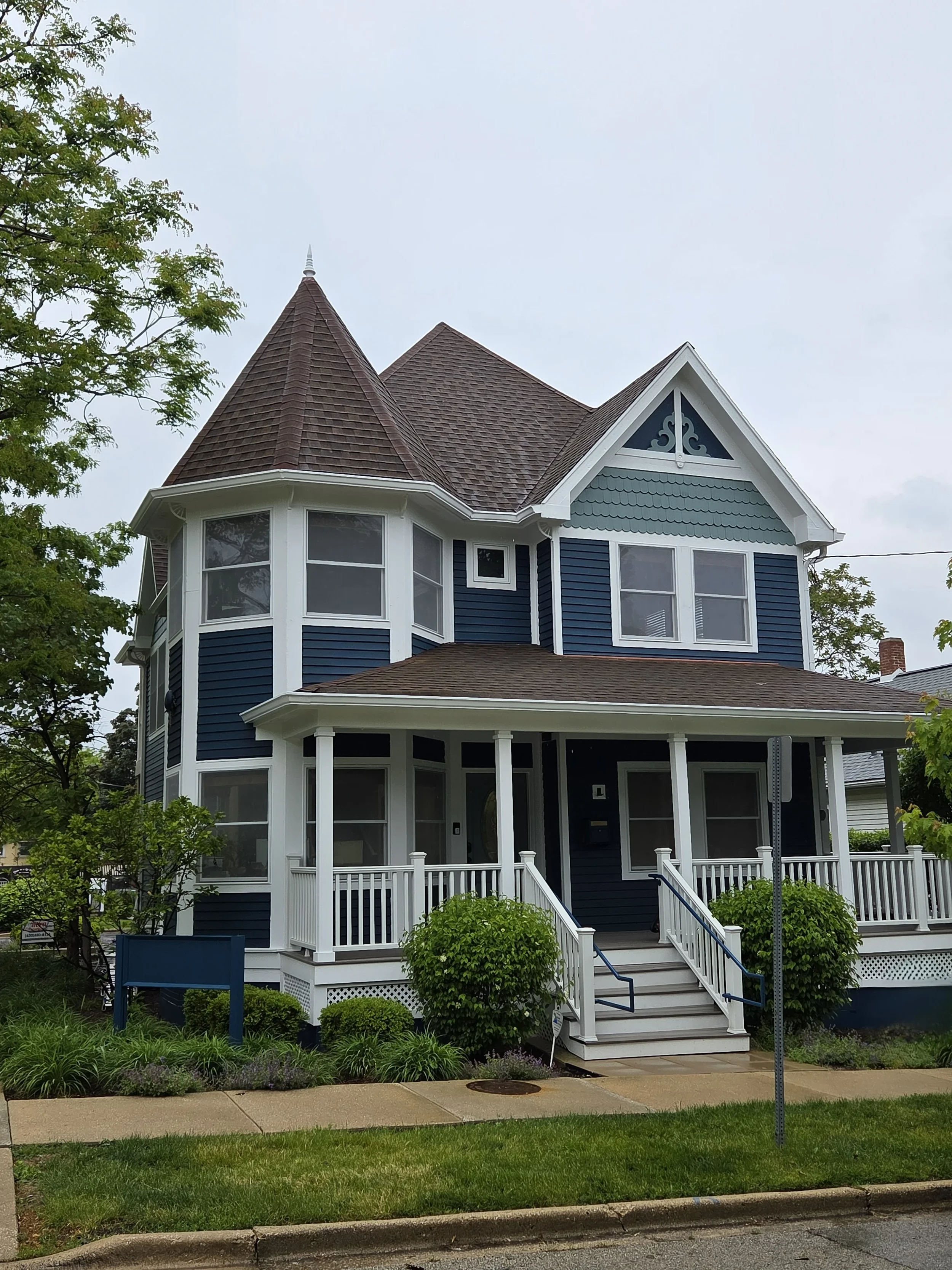 Exterior painting restoration of a historic luxury estate in Wayne, IL. Features preserved cedar siding and custom trim work near Dunham Woods.