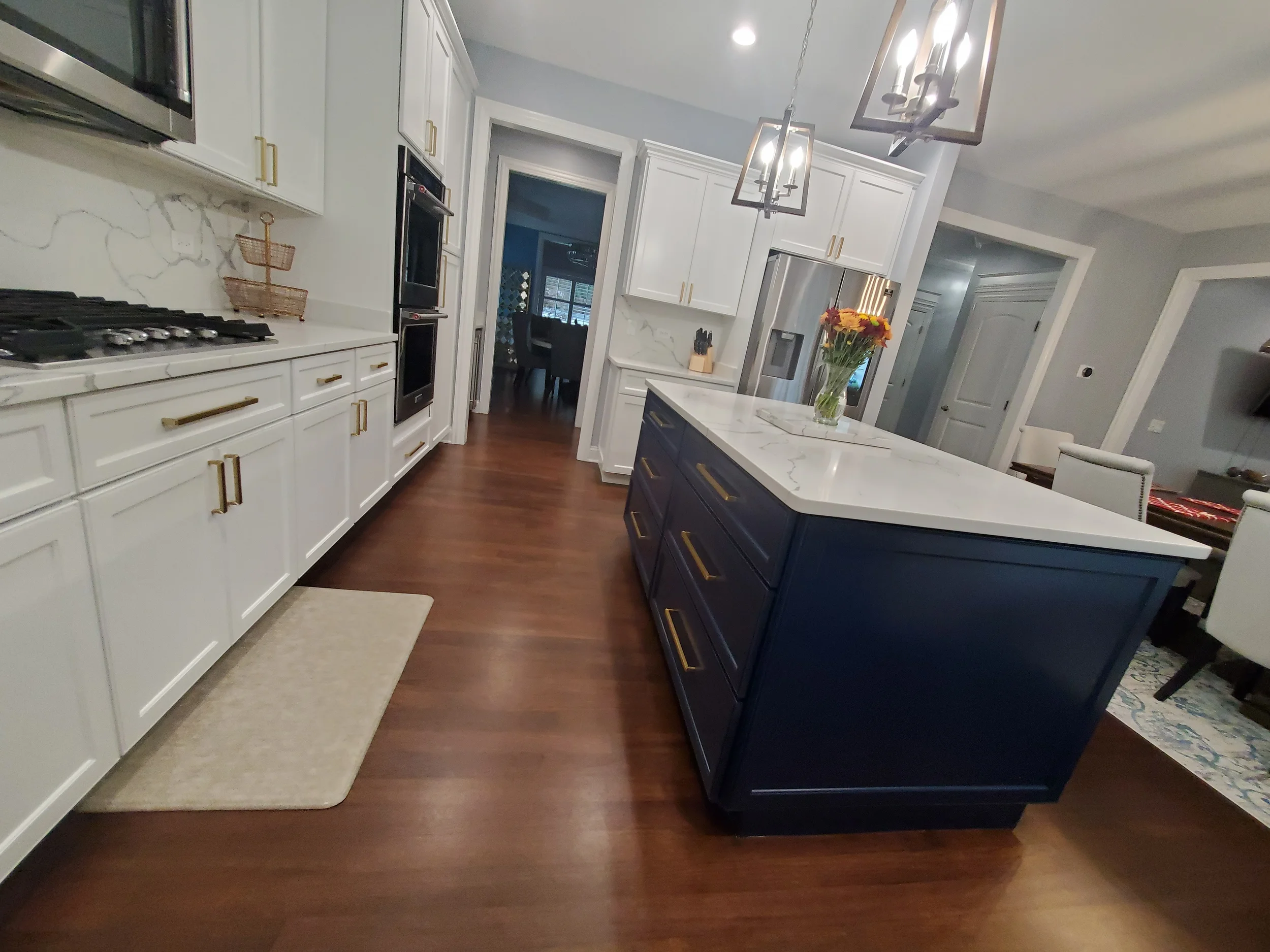 Luxury kitchen cabinet refinishing in Hinsdale, IL, featuring crisp white upper cabinets and a deep blue island with a rock-hard factory finish by Kora Pro Painting.