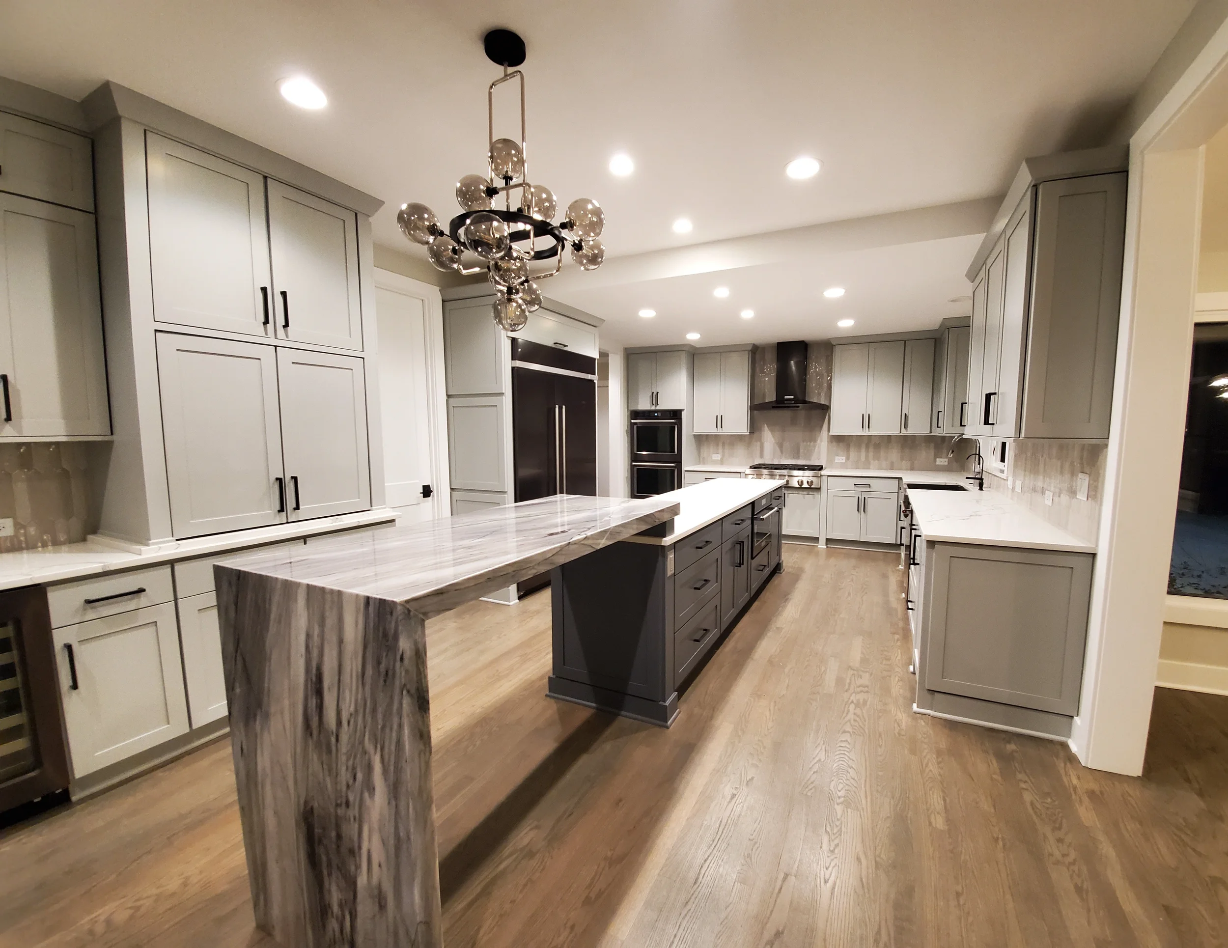 Modern luxury kitchen in a South Barrington estate featuring professionally refinished cabinets, high ceilings, and custom interior painting by Kora Pro Painting near The Arboretum.