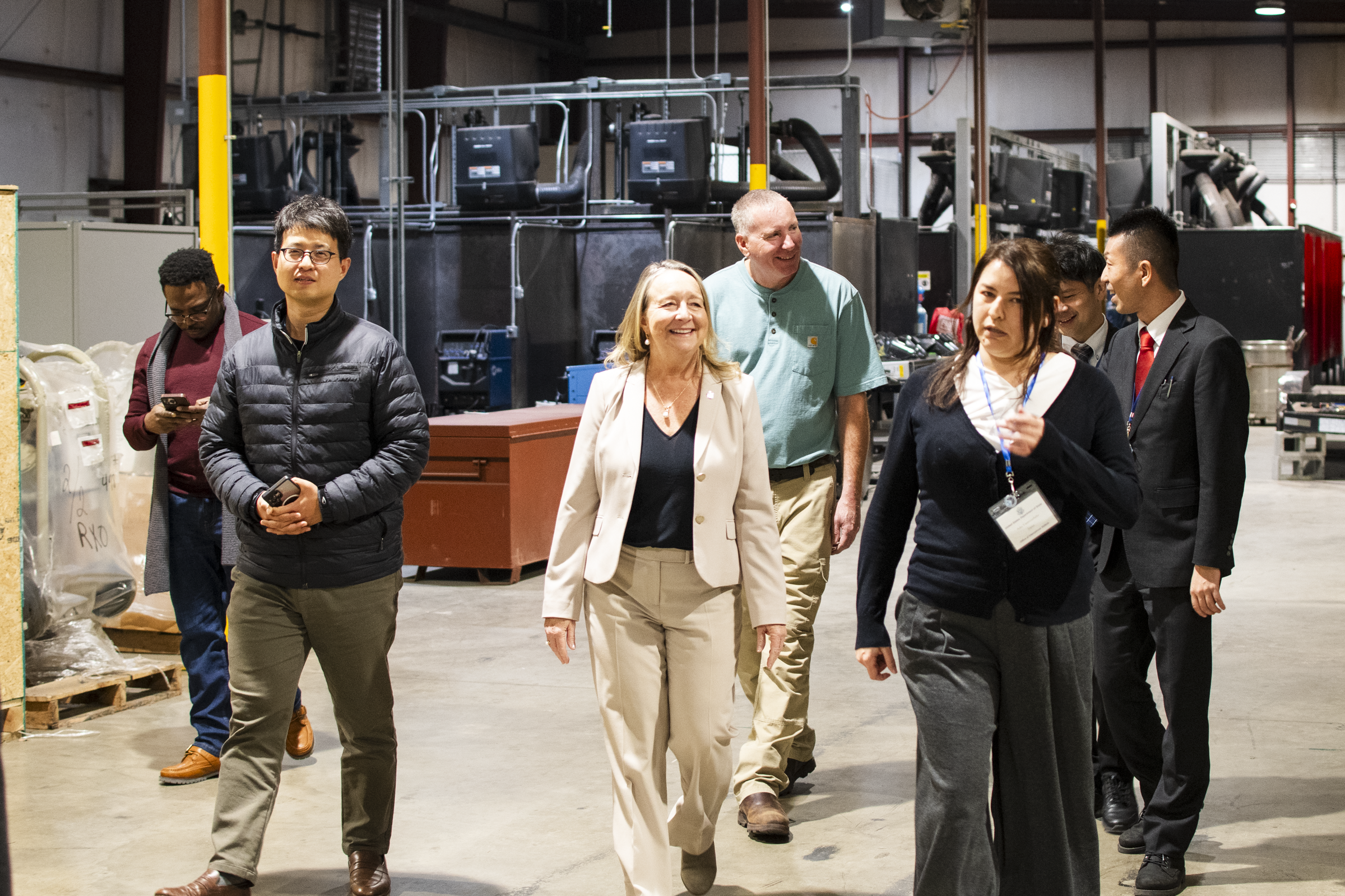 Group of professionals walk through a manufacturing facility