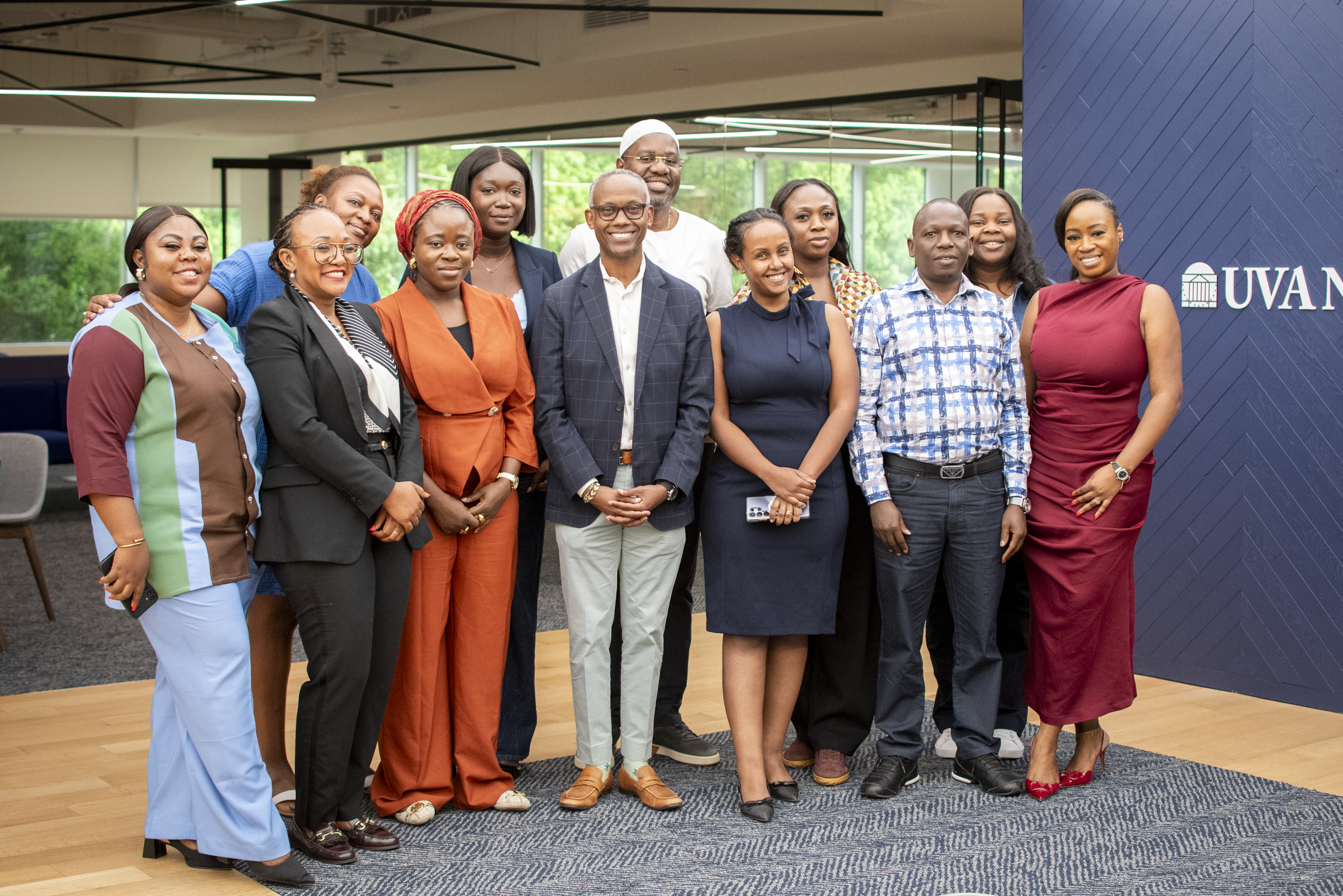 Group of diverse professionals posing together indoors at UVA, smiling for the camera.