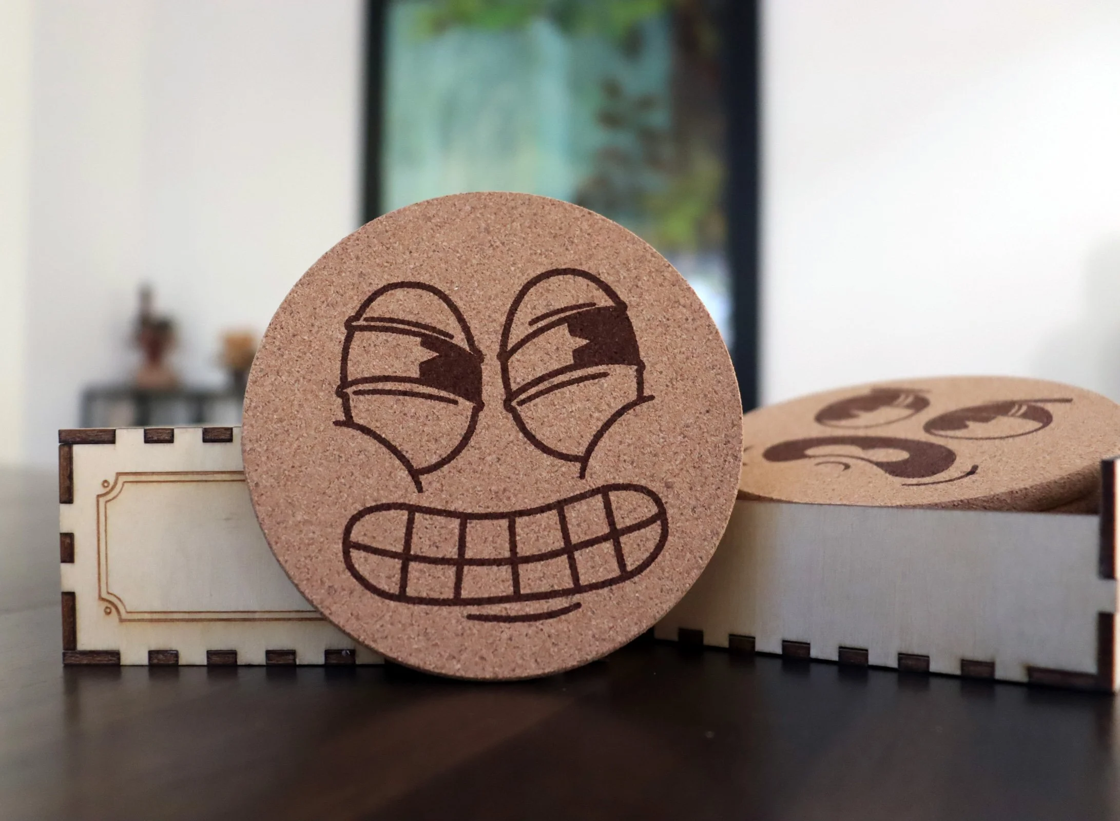 Rascal Cork coaster engraved with sly pie-eyed cartoon expression