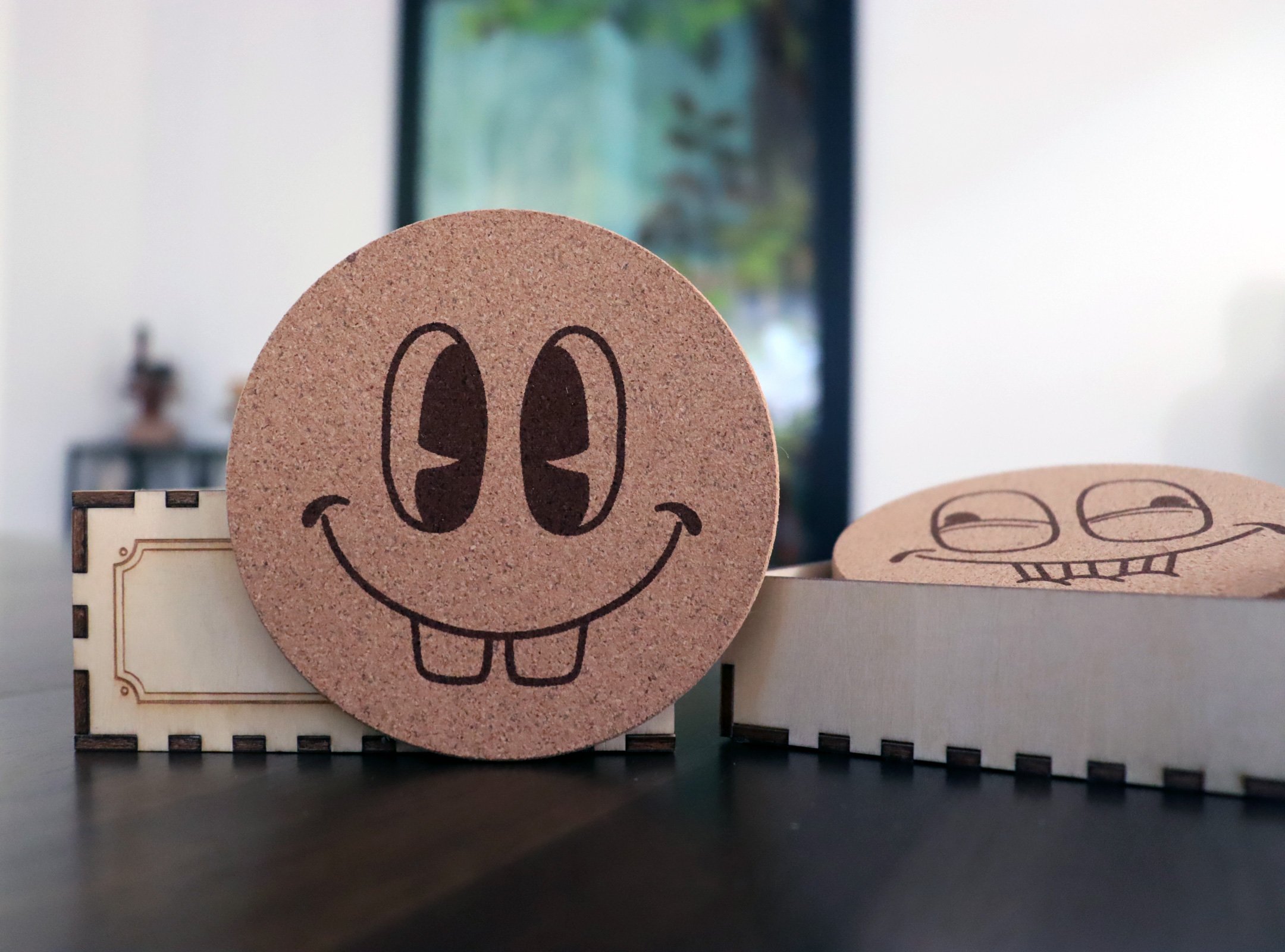 Golly_Gee Cork coaster engraved with cheerful pie-eyed cartoon face