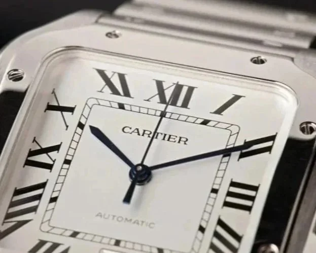Close-up of a Cartier watch with a square face, Roman numerals, and black hands, showing the time as approximately 10:10:30.