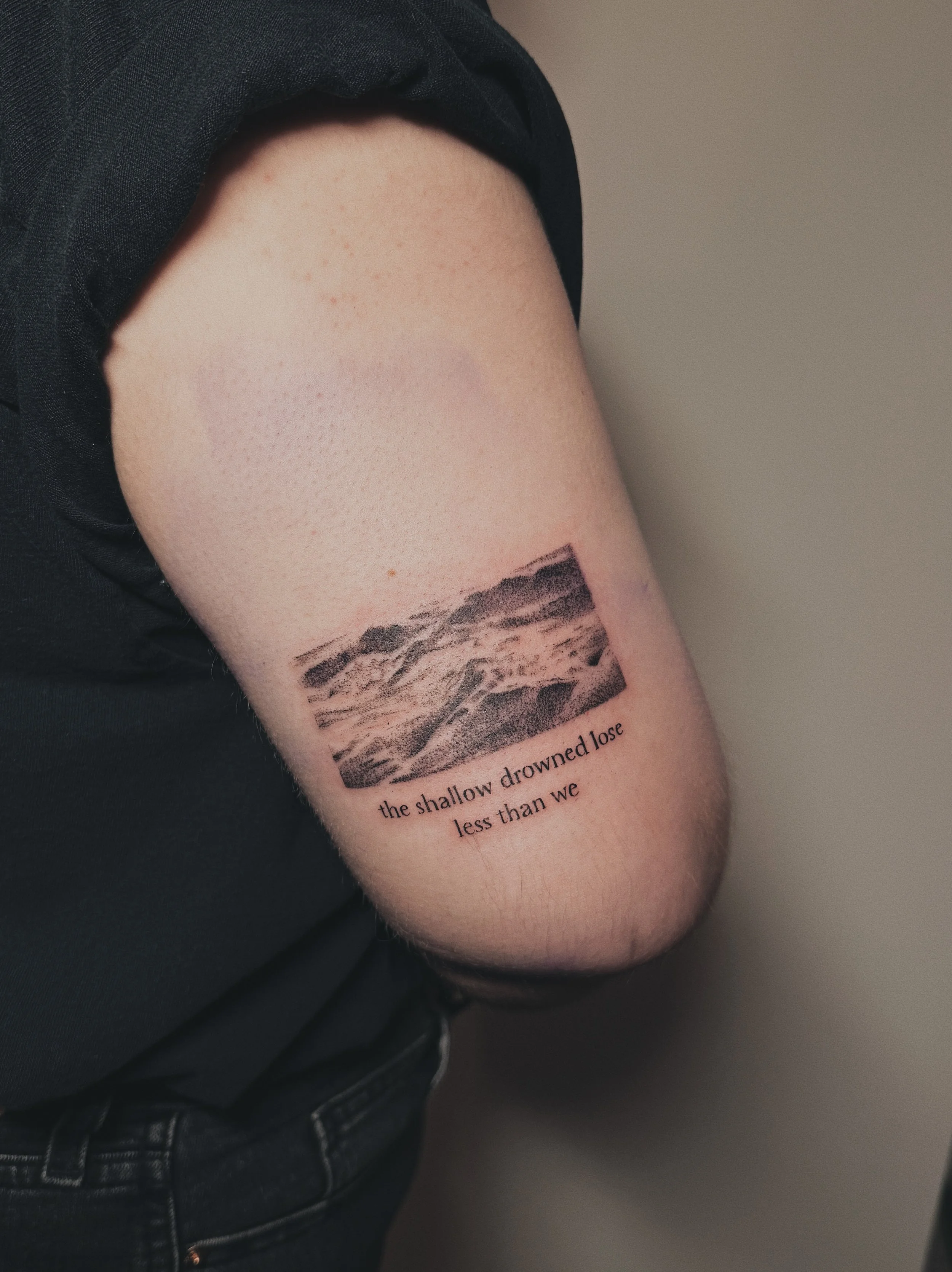 dotwork tattoo of a photo of story ocean water. text from a song underneath