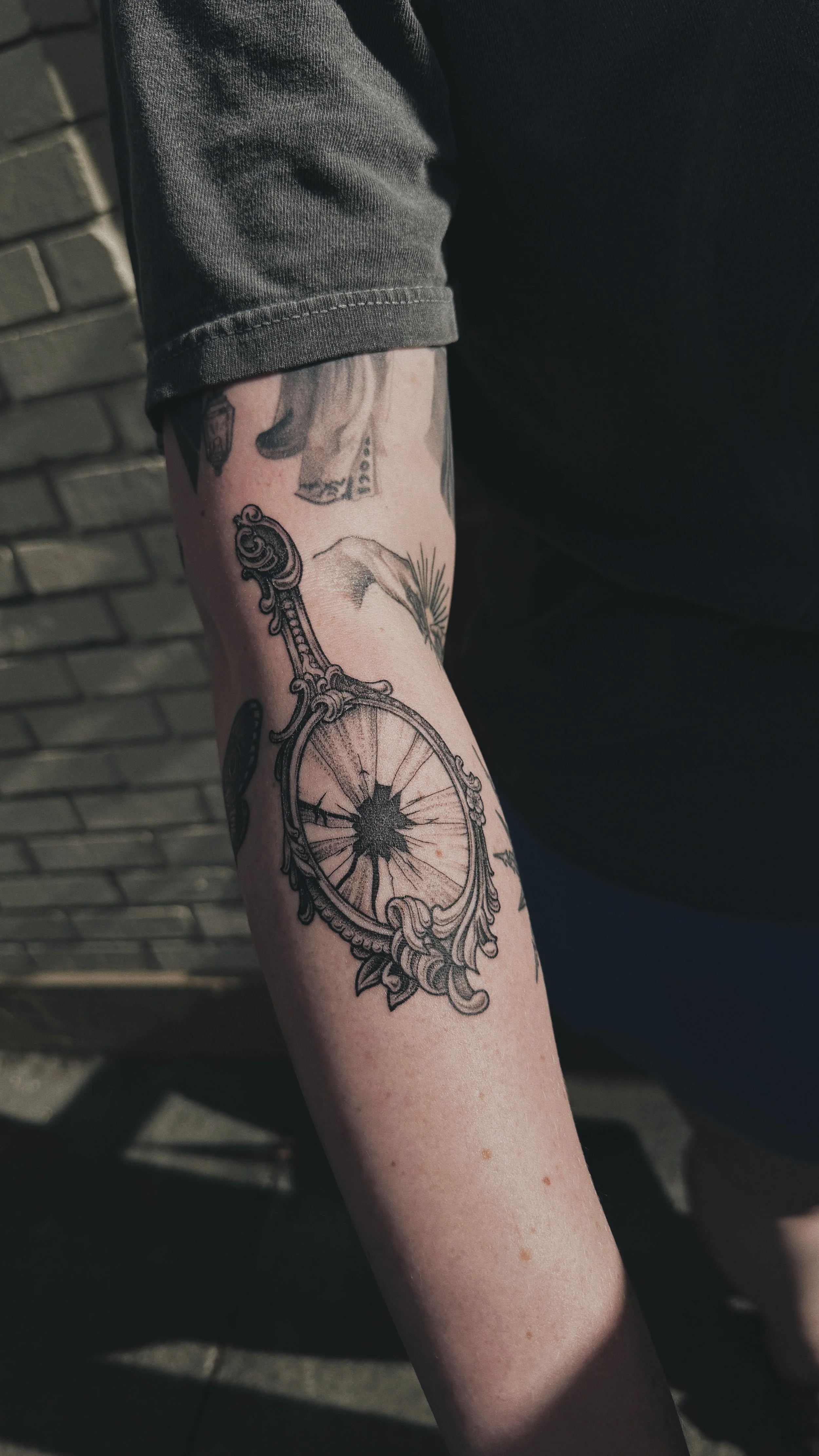 blackwork illustrative dotwork tattoo of a broken shattered antique mirror
