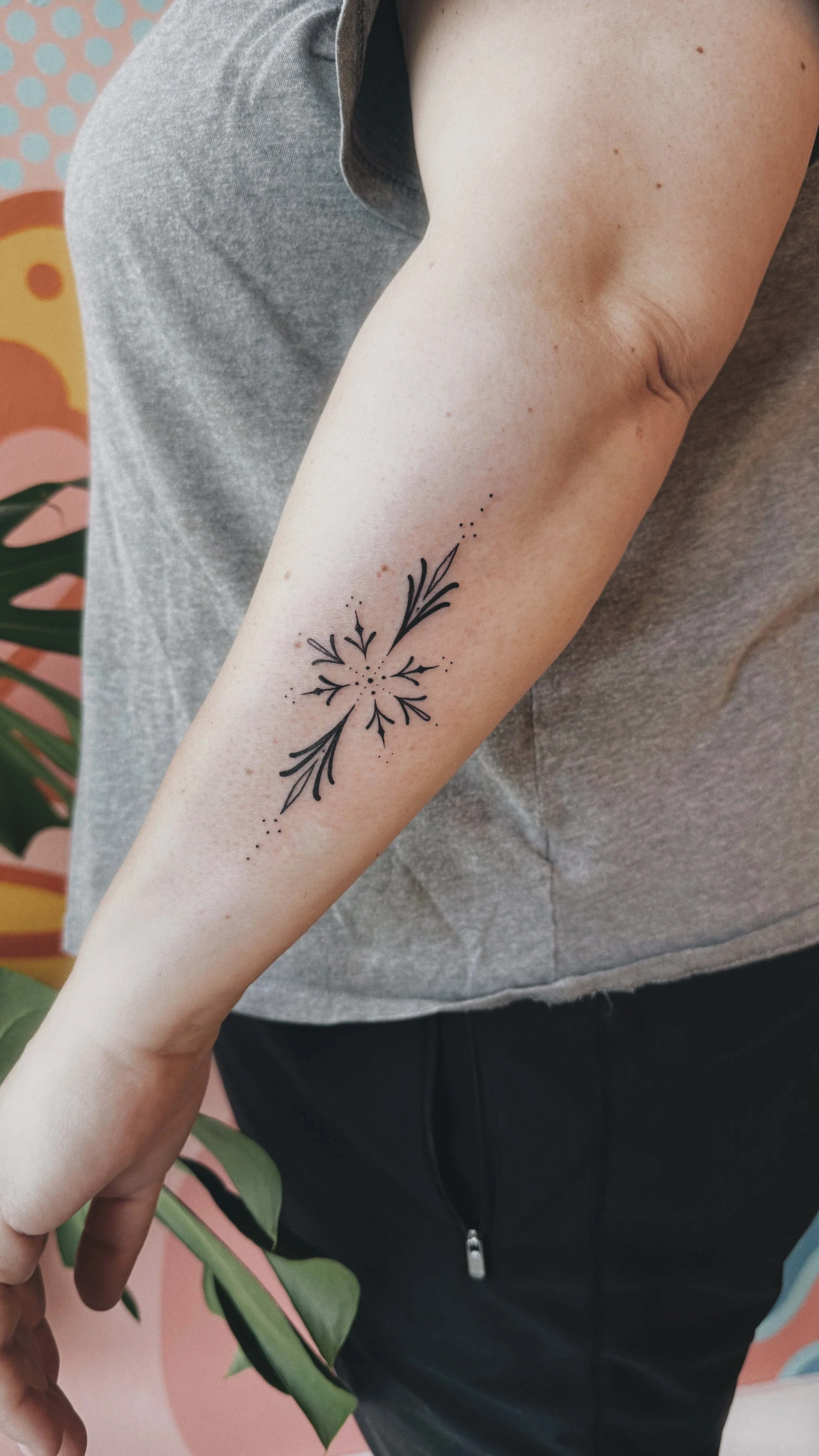 minimalistic ornamental tattoo on side of arm