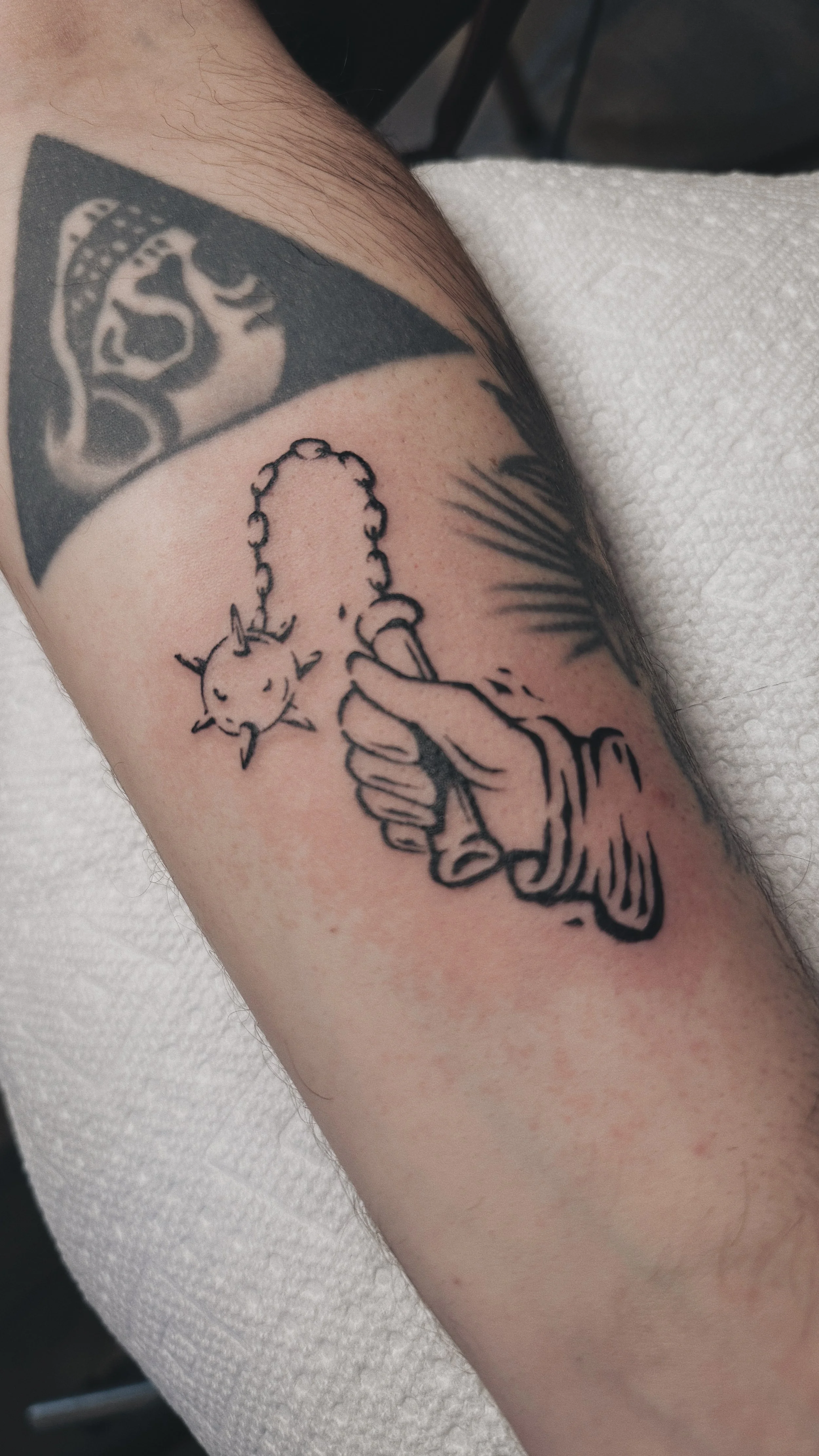 linocut inkblot medieval blackwork linework tattoo of a  hand holding a flail morningstar