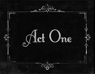 Chalkboard sign displaying 'Act One' in elegant white script with decorative borders.