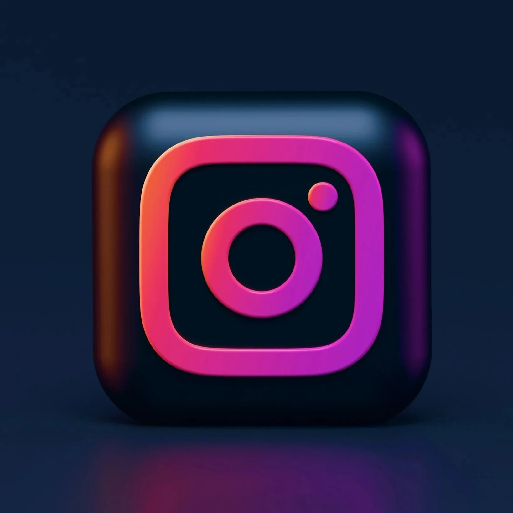3D icon of the Instagram logo with pink, purple, and orange gradient on a dark background.