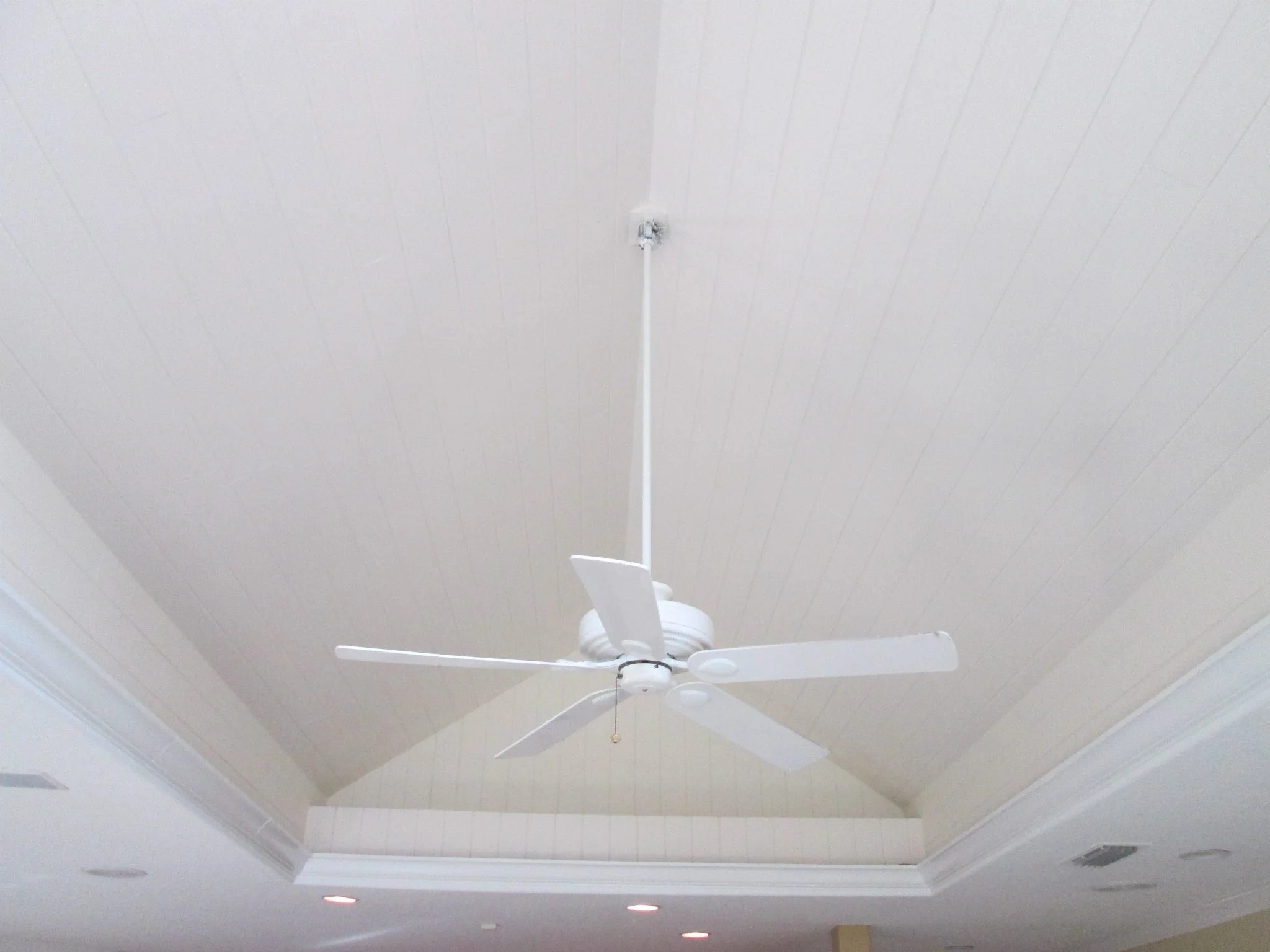After: Fresh white ceiling paint with crown molding and recessed lights.