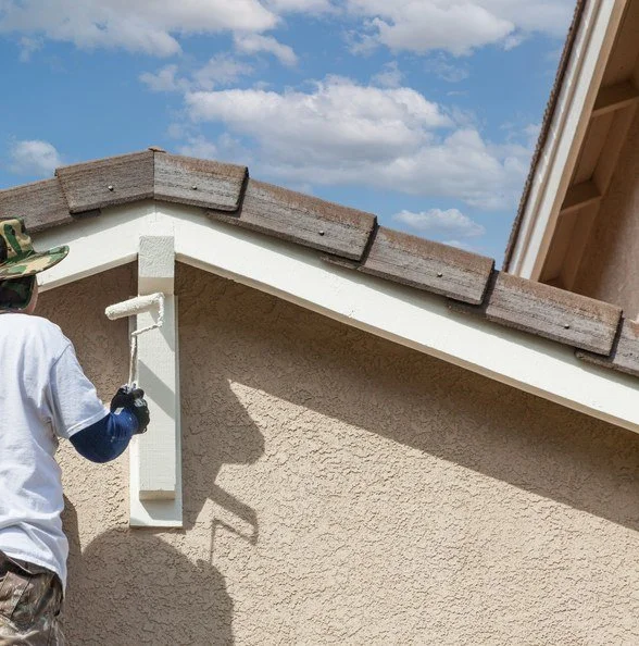 Professional painter applying fresh paint to exterior house trim in Palm Coast and Ormond Beach, FL