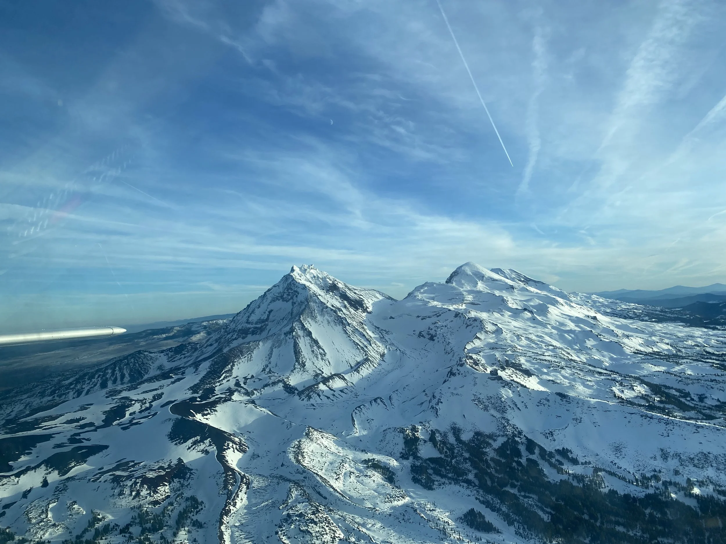 Scenic aerial view of snowy Cascade Mountains during flight training near Bend, Oregon