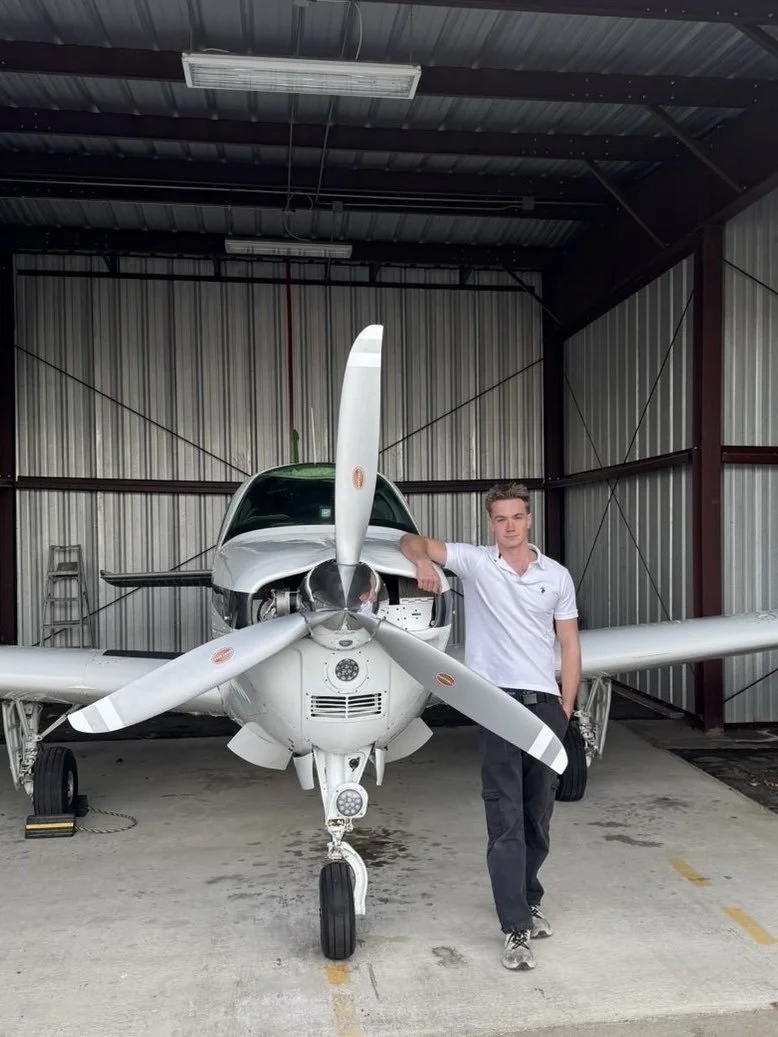 Flight instructor Quintin Reid standing beside a training airplane in the hangar at Bend Municipal Airport