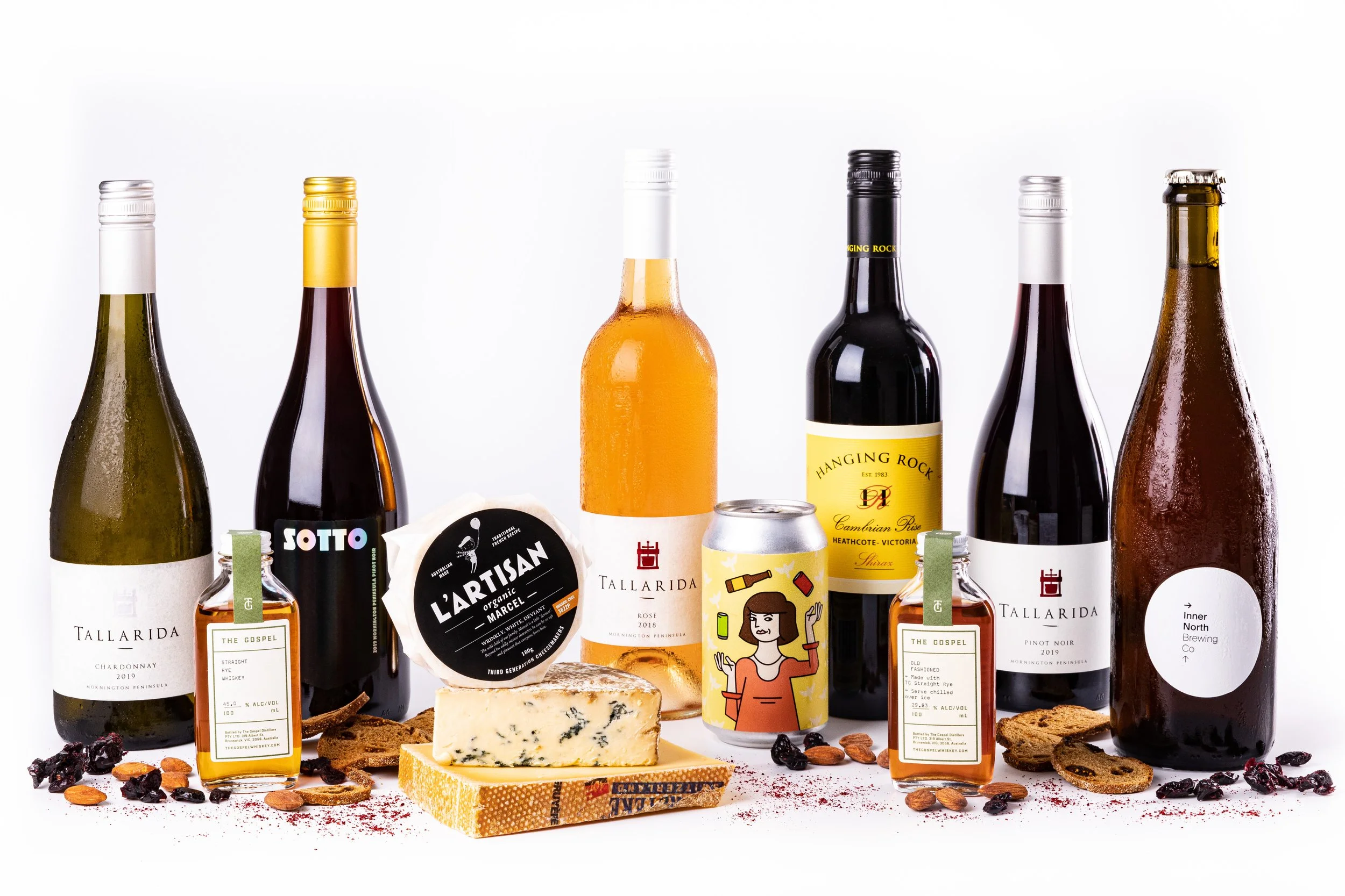  assortment of wine bottles, cheese, snacks, and a beverage can on a white background.