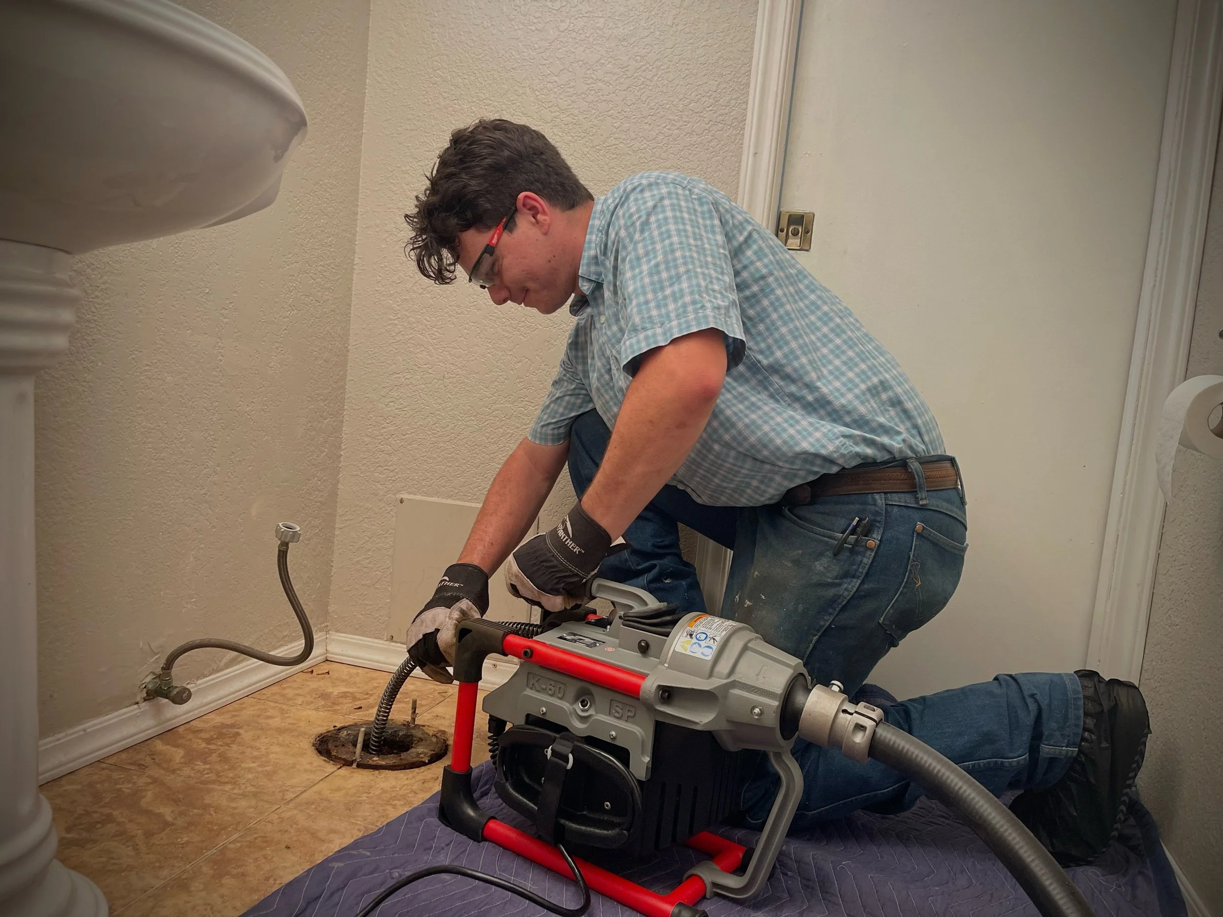 Snaking drain through the toilet flange to clear the a whole house or bathroom stoppage or a toilet clog