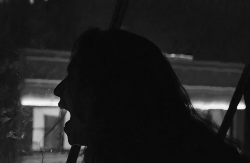 Silhouette of a person in profile inside a dark vehicle