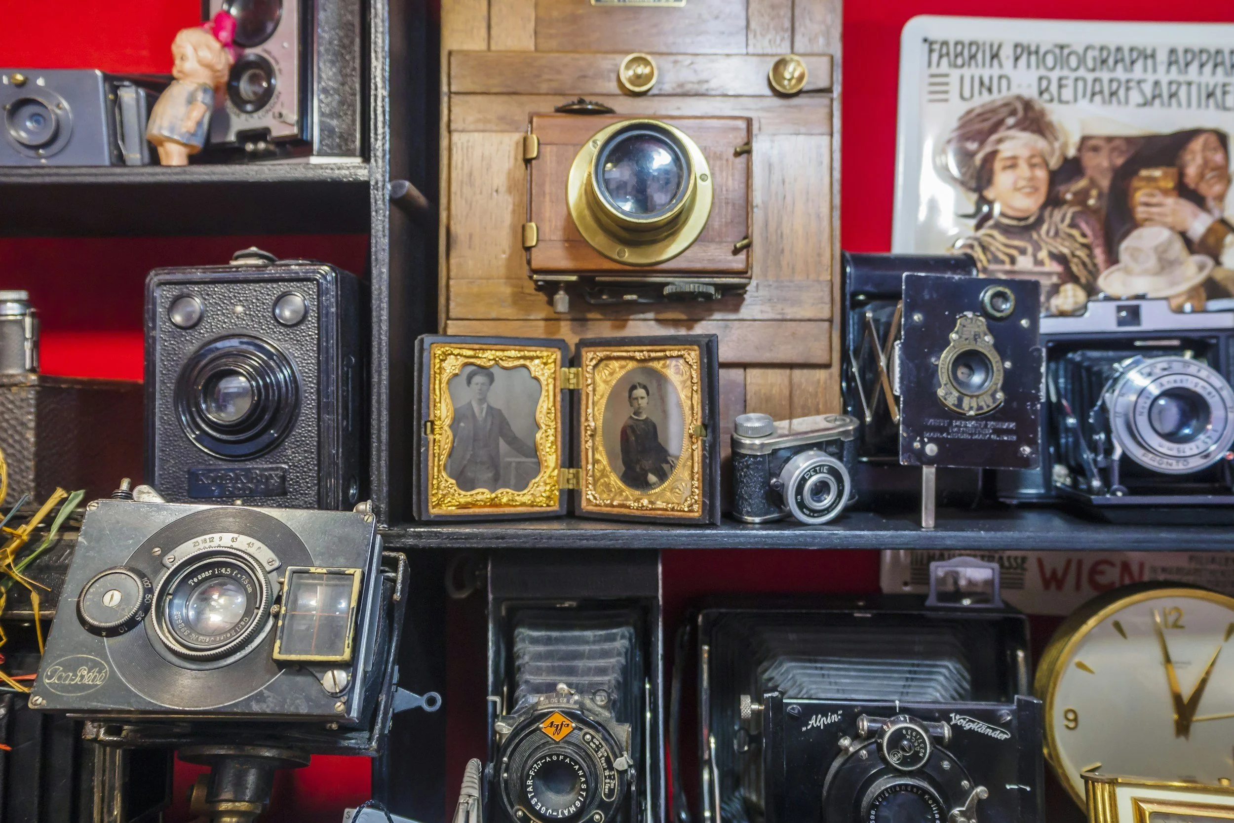 A collection of vintage cameras, photographs, and memorabilia displayed on shelves.