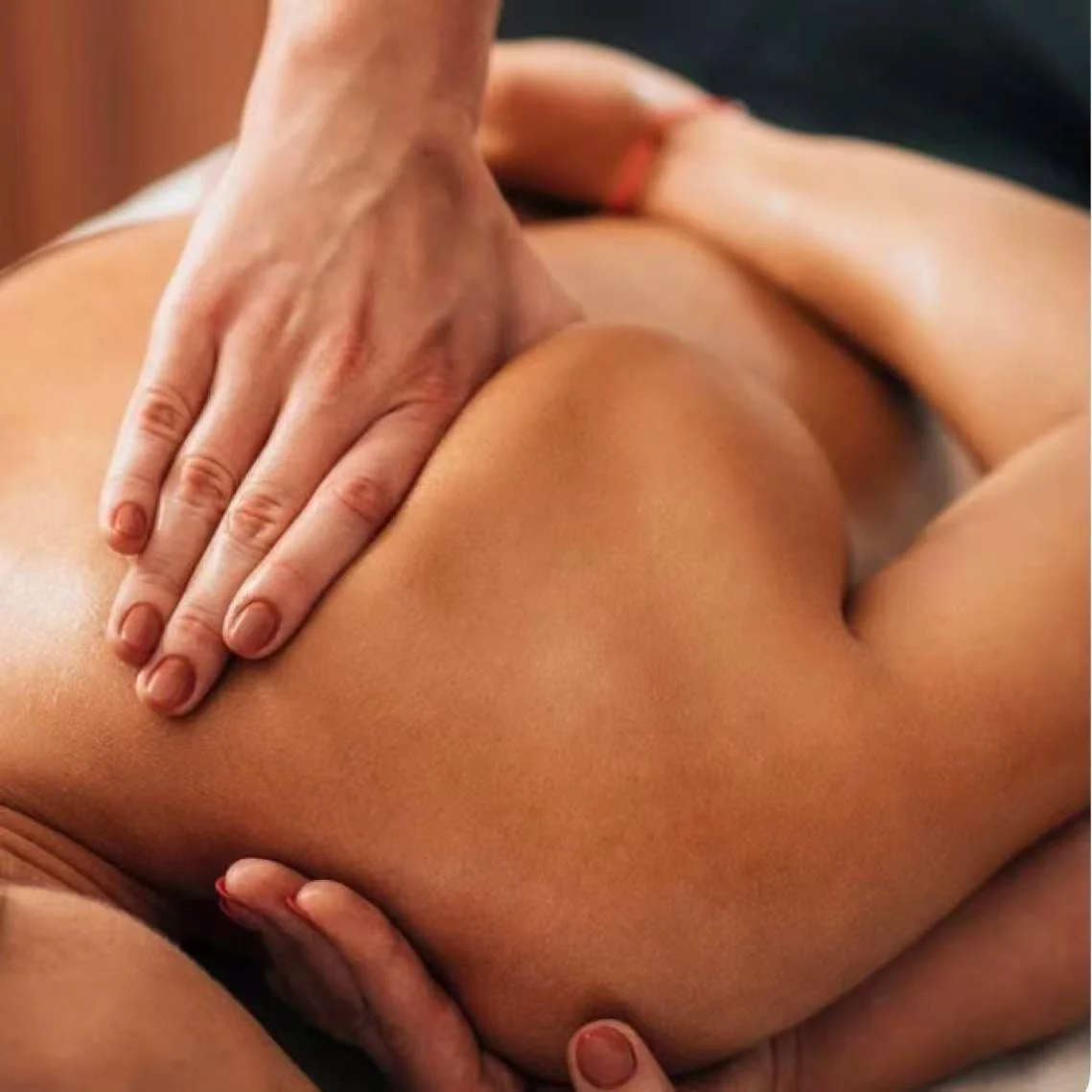 Close-up of a person receiving a massage, focusing on their back and shoulder area.