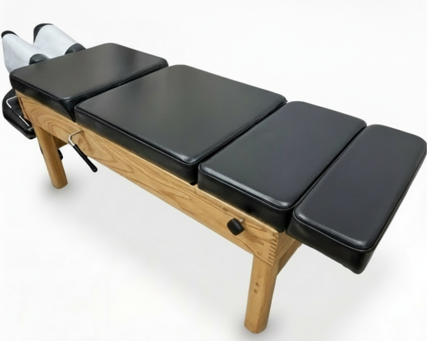 Chiropractic or massage therapy table with black padded surface and wooden frame, set against a plain white background.