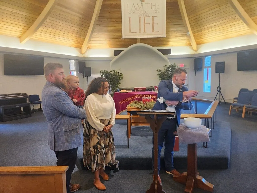 Pastor Ben Alexander Baptizing Baby Parents Watch Beside
