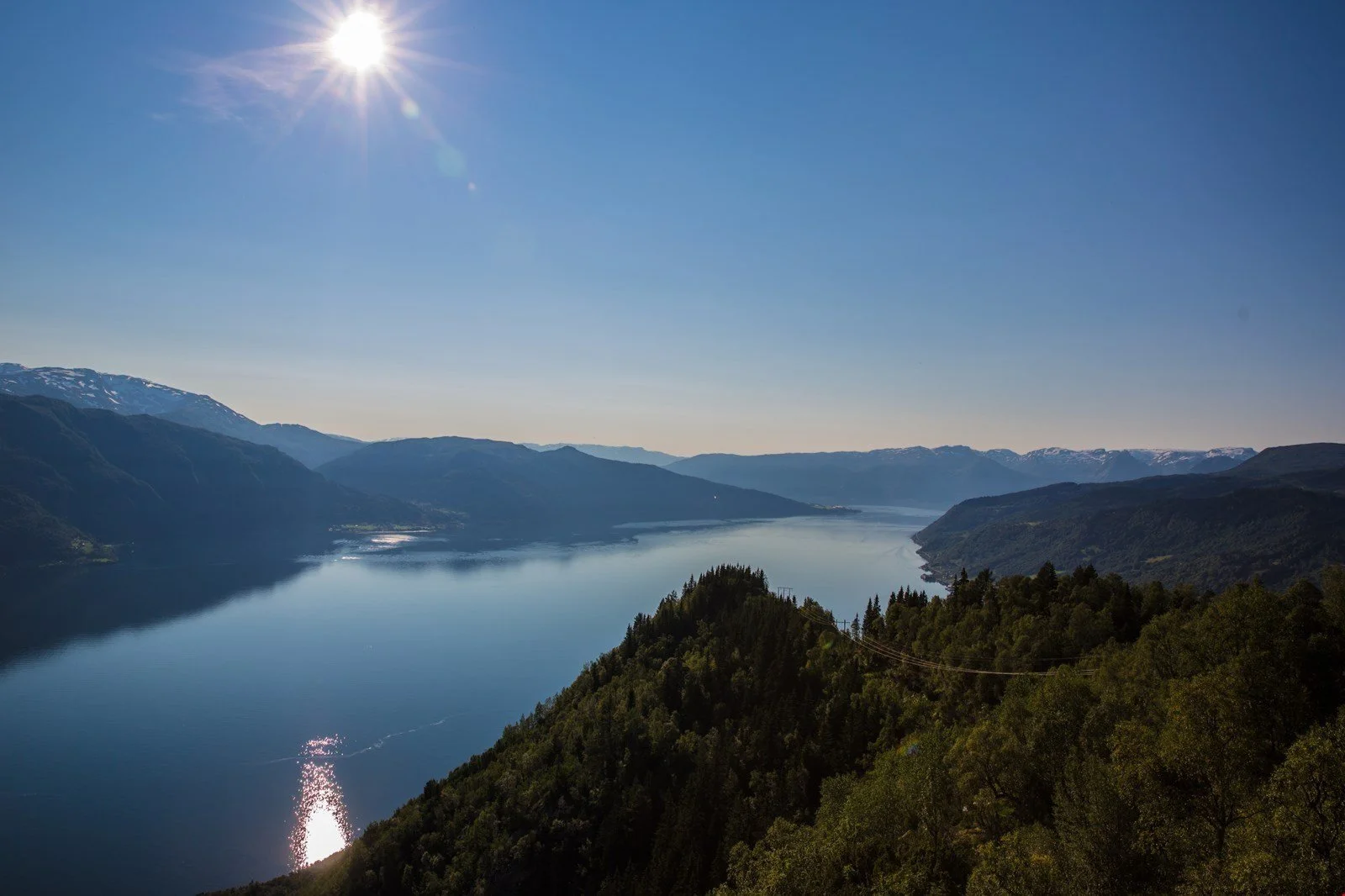 Landskapsbilete ein sommardag med fjell og fjord.