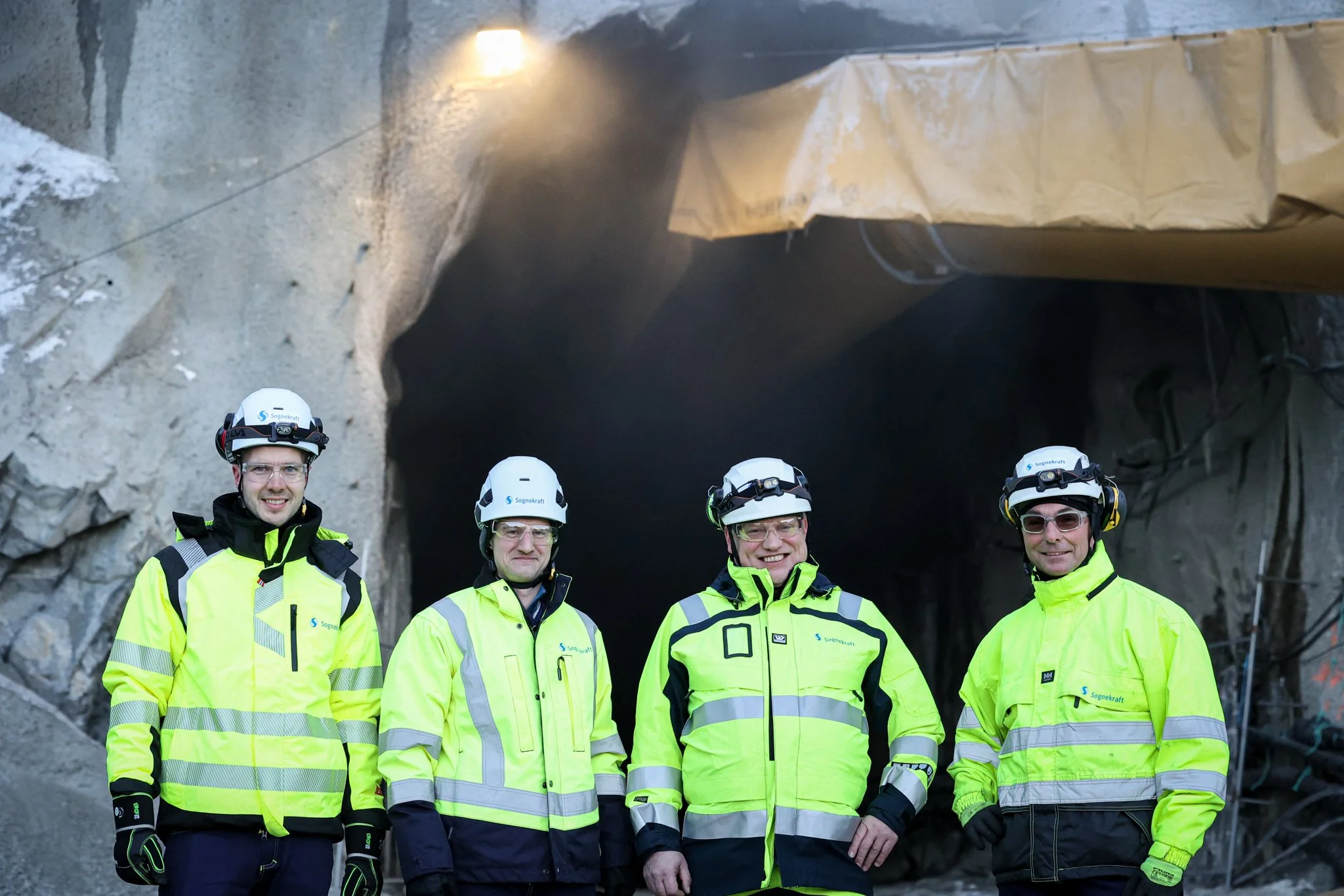 Fire Sognekraft-karar med verneutstyr foran tunnel ved Håastrondi.