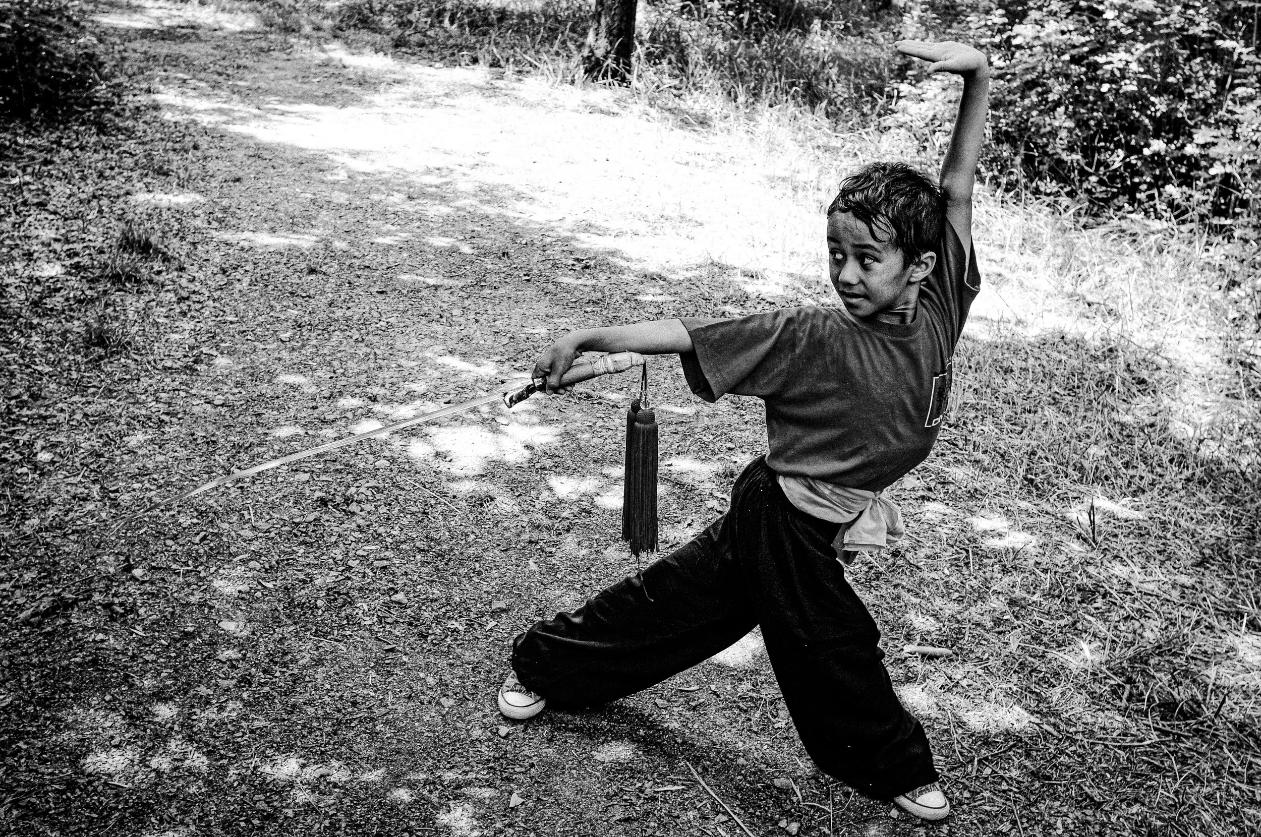 Ragazzo che pratica il tai chi in un sentiero naturale 