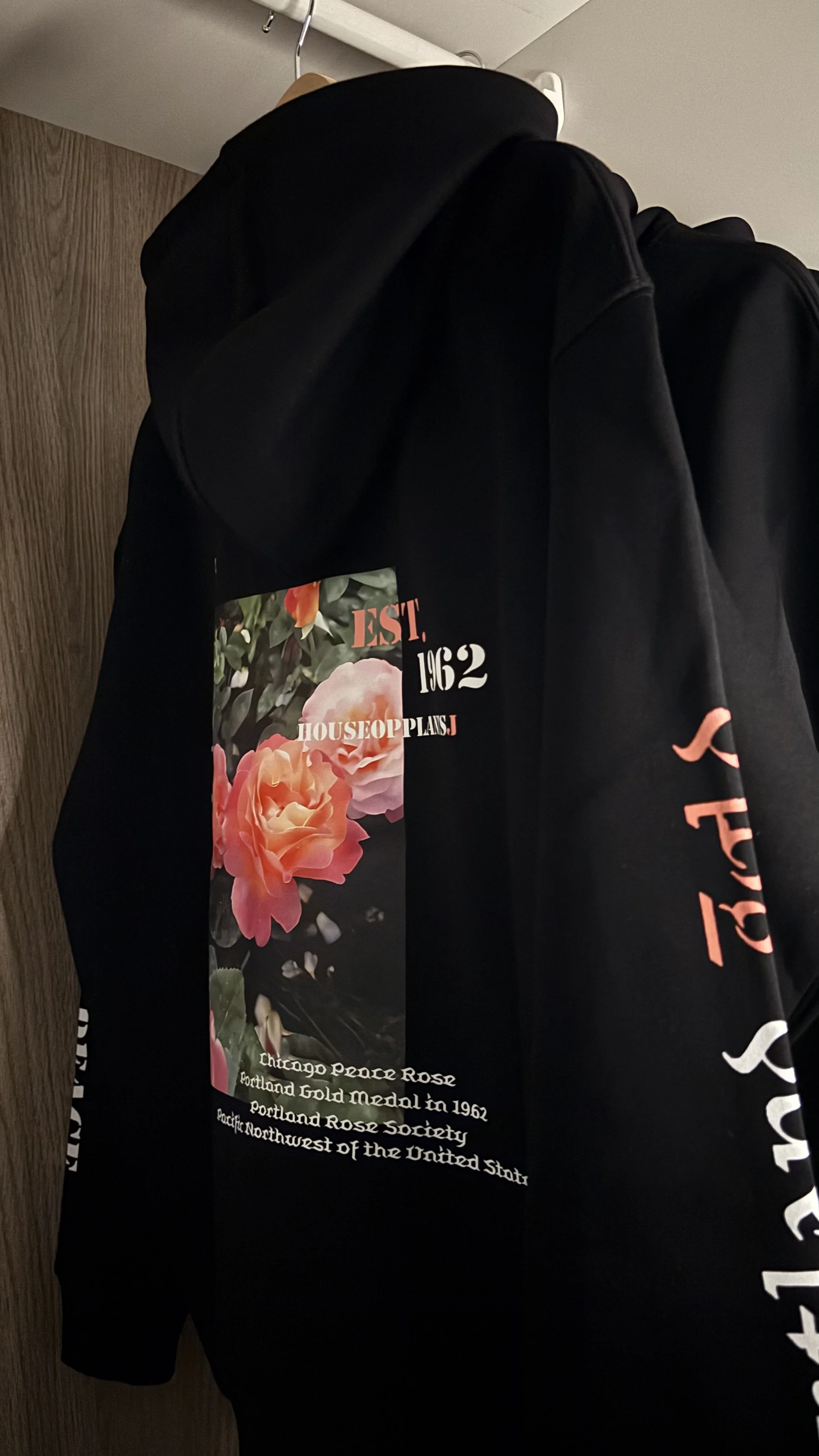 Black hoodie with floral graphic and text about Chicago Peace Rose, established in 1962, Portland Gold Medal, Portland Rose Society, and Northwest United States.