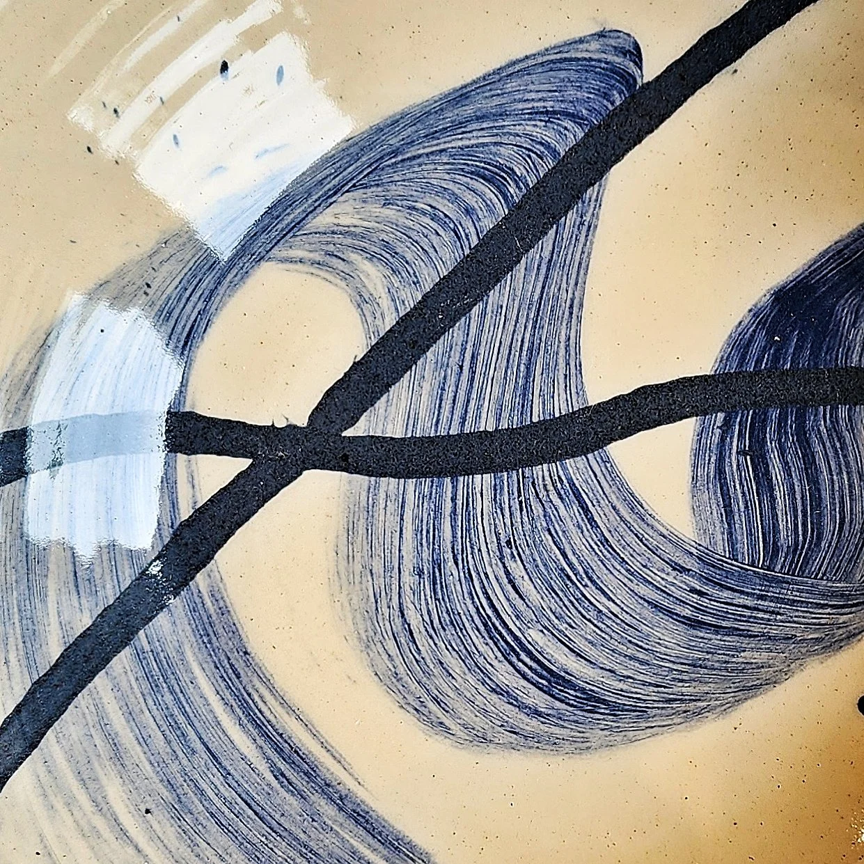 Close-up of a bowl with sweeping black and blue strokes on a white background.