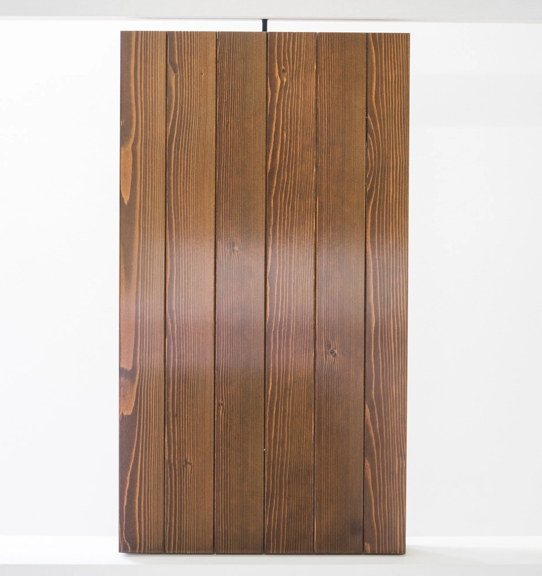 Parete di pannelli di legno marrone scuro con venature visibili.