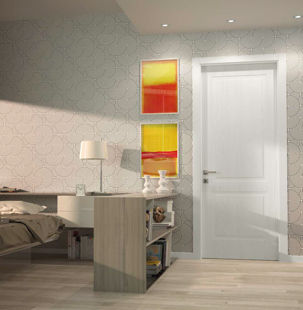 Interno di una stanza con pareti rivestite con carta da parati a motivi circolari, porta bianca, quadri con colori caldi e una piccola libreria.