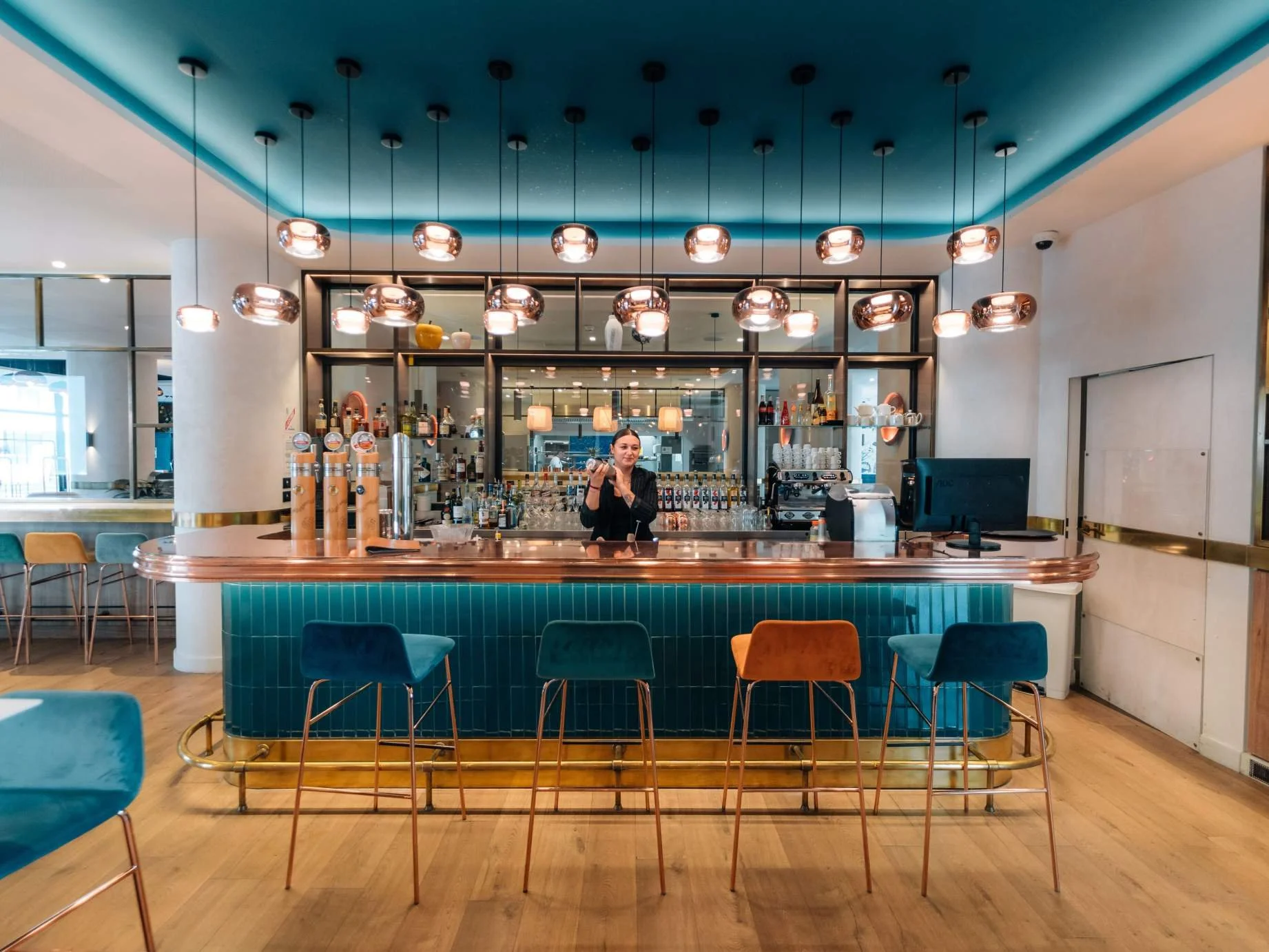 Bar de l’hôtel Golden Tulip avec un design moderne et coloré, parfait pour des cocktails et des réunions sociales