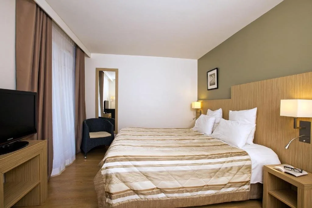 Chambre moderne et fonctionnelle du Residhome Arcachon Plazza, avec un lit confortable et un design contemporain.