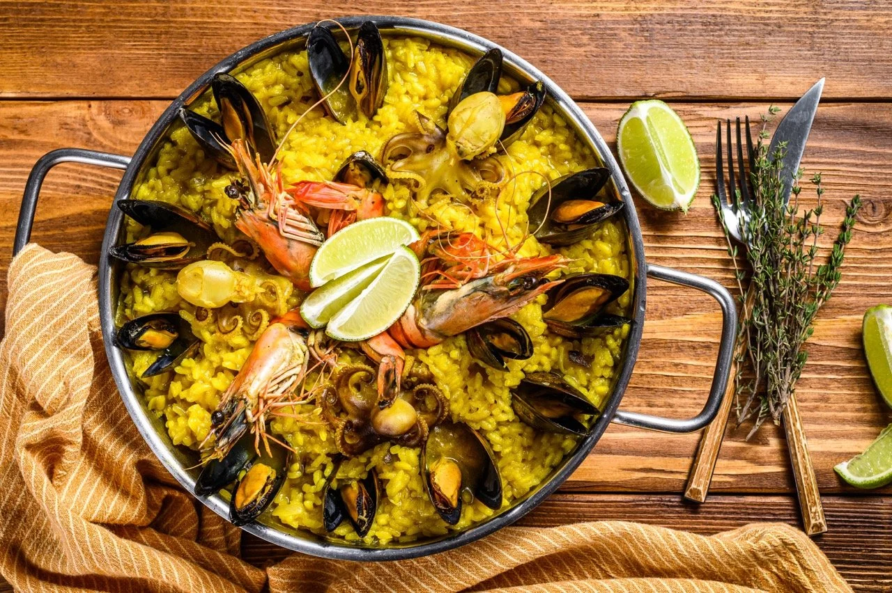 Gastronomie espagnole : paella de fruits de mer, un plat qui représente l’expérience culinaire lors d’un voyage ou d’un événement AYLO.
