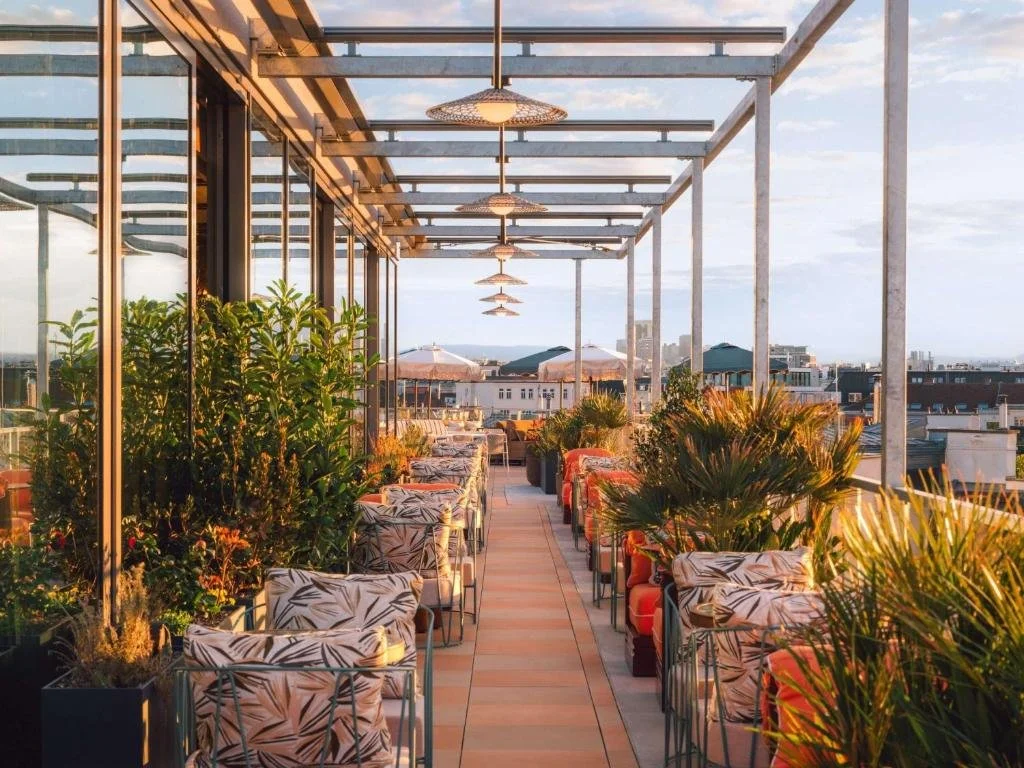 Terrasse du restaurant de l’Hôtel Hoxton, avec des lumières de chaîne et des plantes, idéal pour les dîners de groupe et événements sociaux