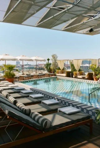 Piscine sur le toit (rooftop) de l’Hôtel Hoxton Barcelona, avec vue sur la ville et aire de repos, idéale pour les cocktails et la détente