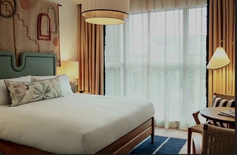 Chambre moderne et lumineuse de l’hôtel Hoxton avec un design intérieur élégant et des œuvres d’art.