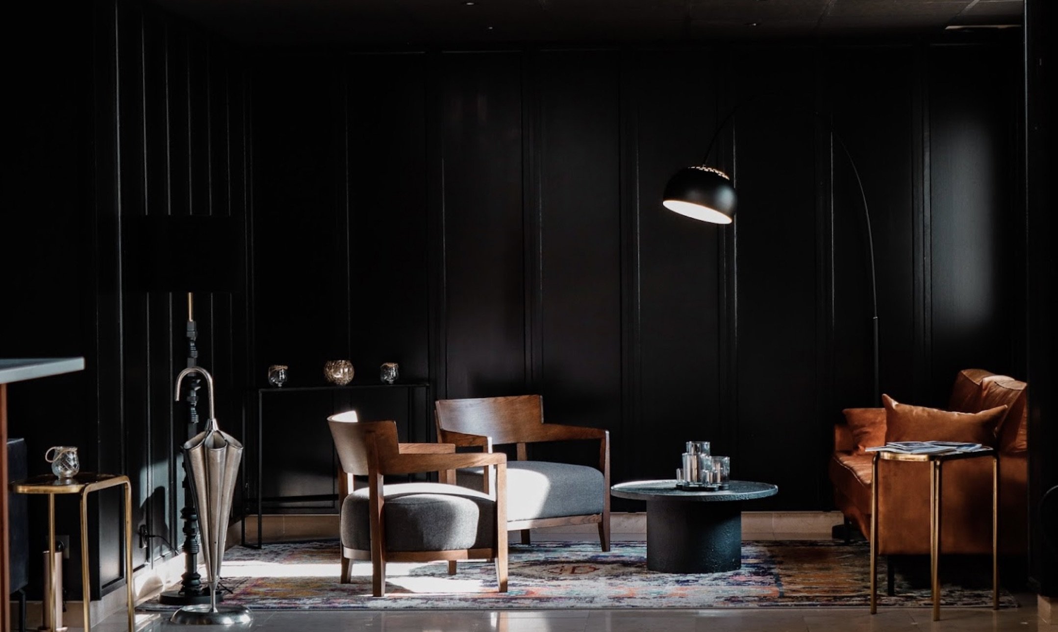 Design intérieur d'un hôtel : coin salon moderne et élégant avec boiseries sombres, fauteuils design et éclairage tamisé, idéal pour les réunions informelles