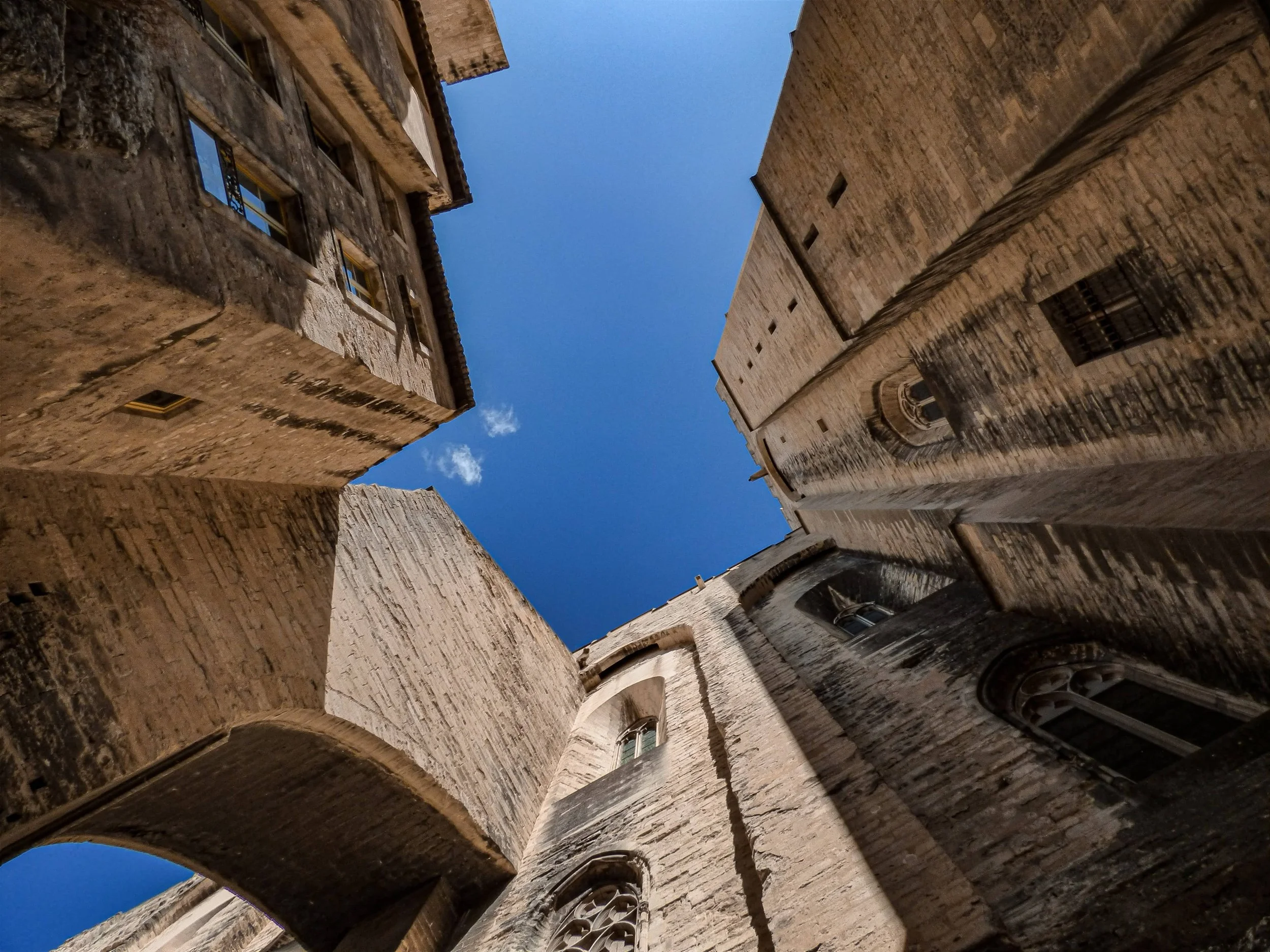 Architecture médiévale en pierre vue en contre-plongée, symbolisant la richesse culturelle d'une destination historique pour les voyages AYLO