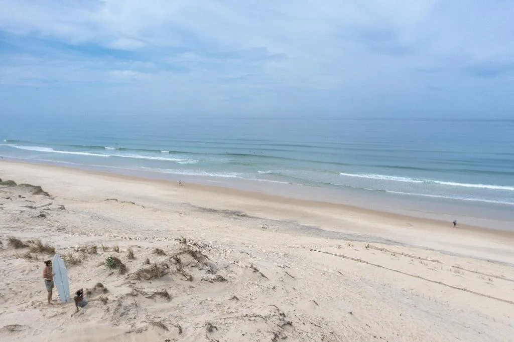 Vue sur la plage de Biscarrosse avec de larges dunes de sable et les vagues de l’océan. Le paysage naturel de la côte est parfait pour se promener et se détendre.