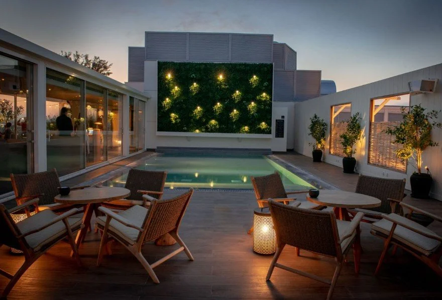 Piscine et salon de l’hôtel Marriott à Athènes, avec un design moderne et un éclairage nocturne pour les événements.