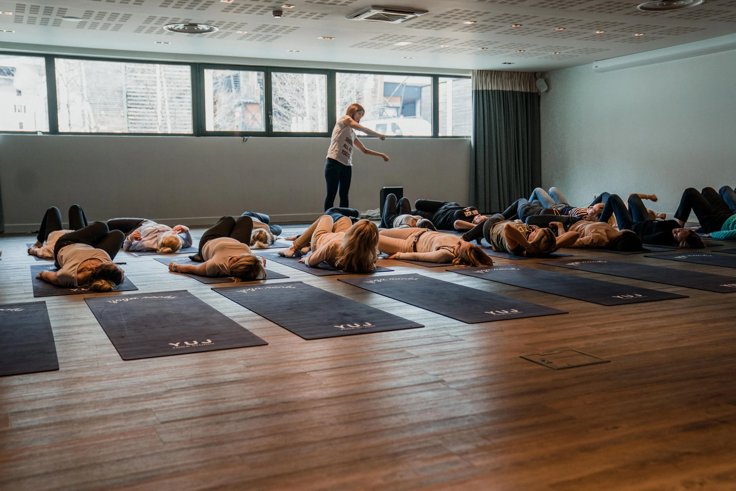 Cours de yoga pour les retraites de bien-être d’AYLO : un groupe d’entreprise se détend dans un studio moderne.
